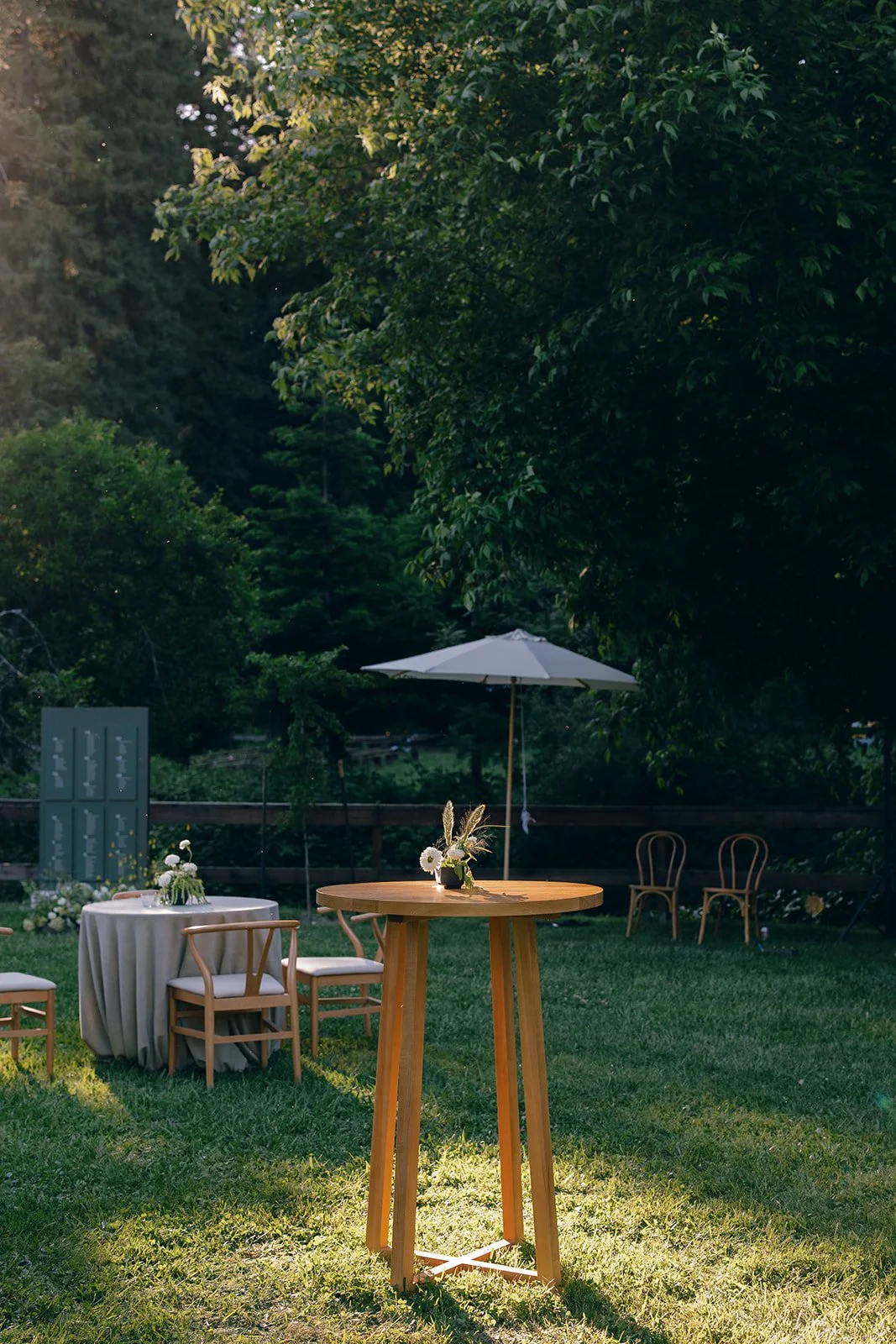 cocktail tables with smalll arrangement under redwood trees