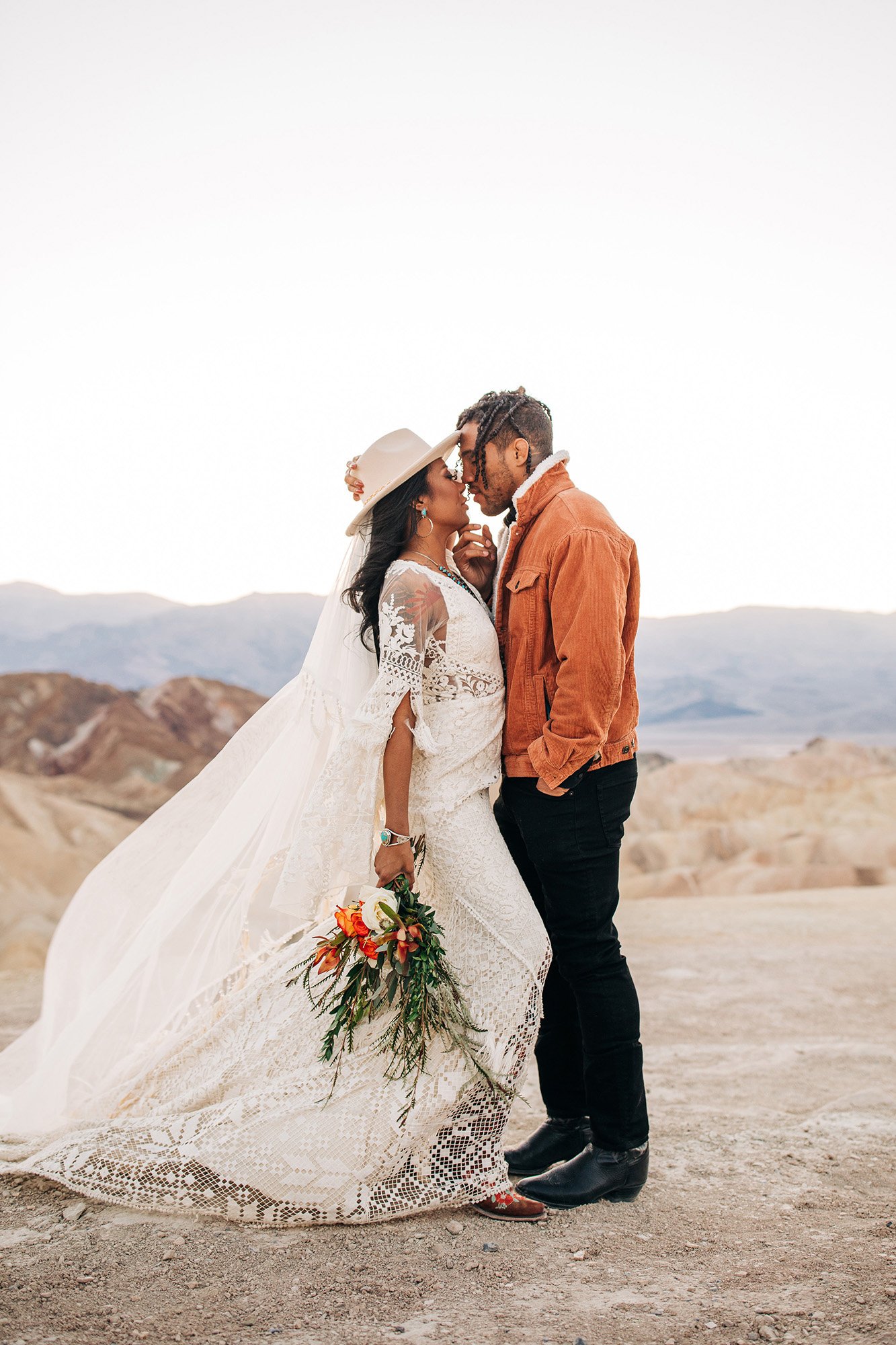 Mieko and Kevin, dressed in their wedding attire, kiss in Death Valley after their wedding.