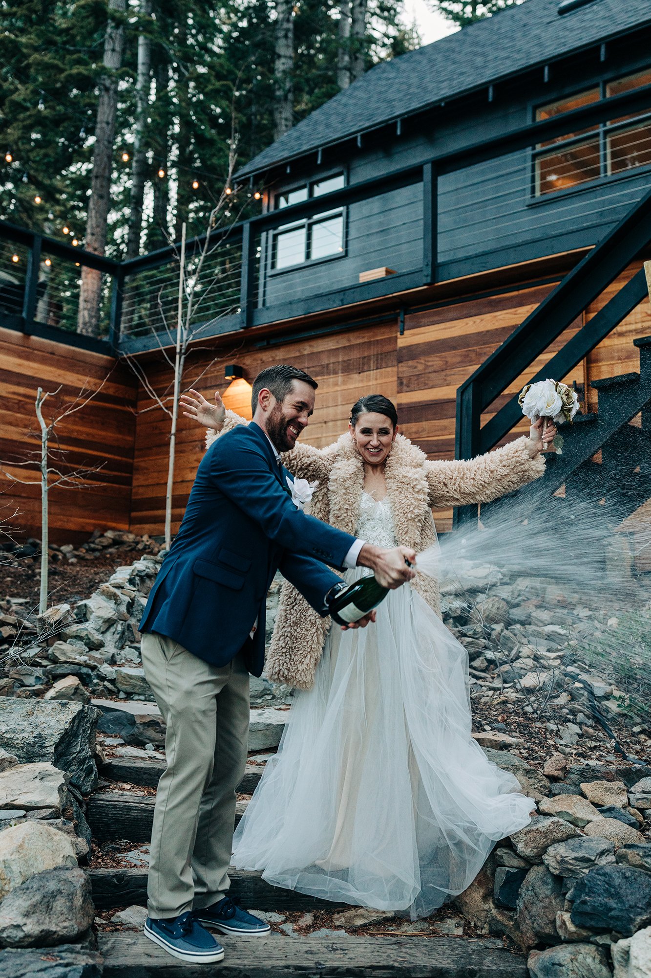 A couple celebrates while spraying champagne at their Tahoe Airbnb. 