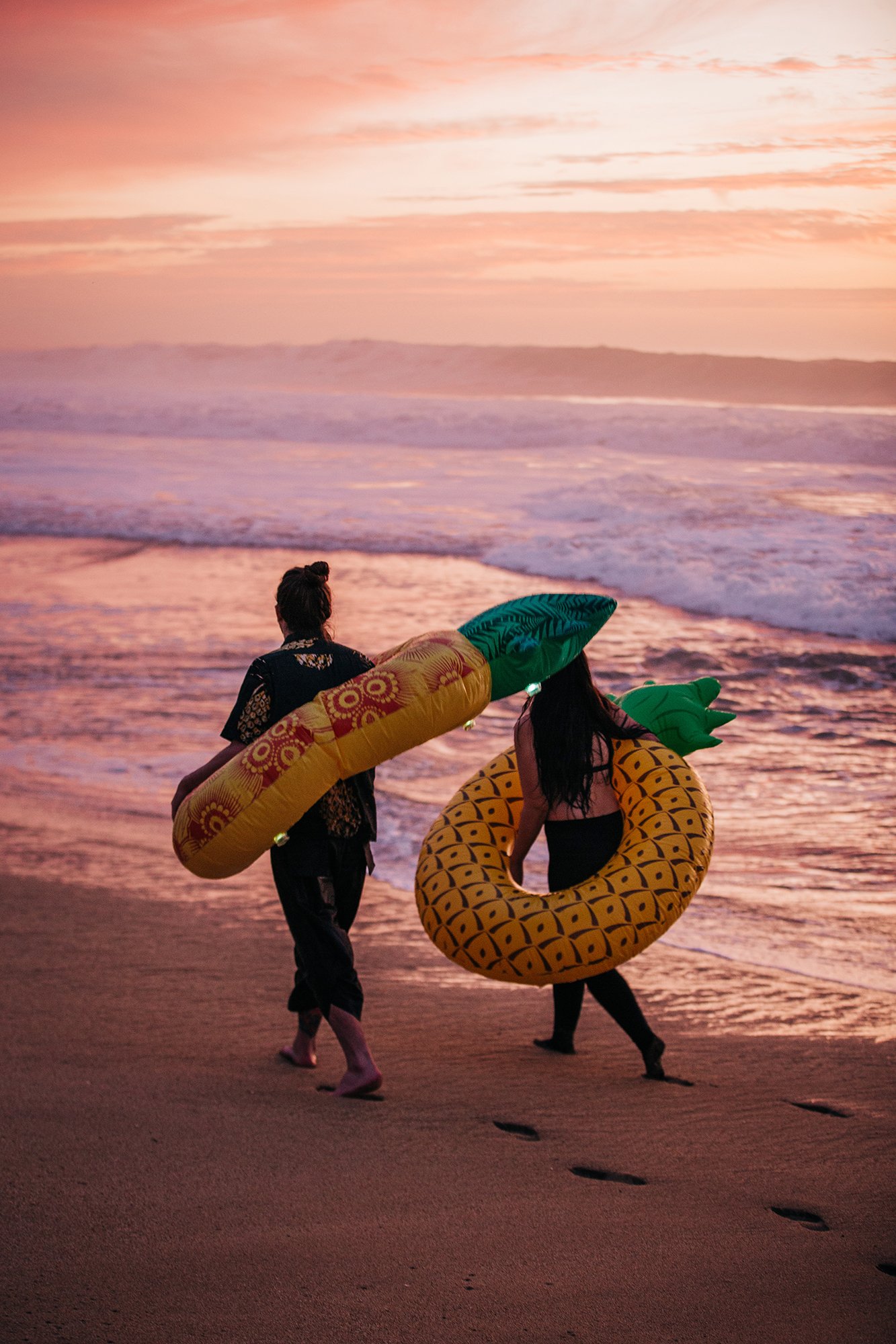 Sean and Diana carry floaties along a Northern California beach.