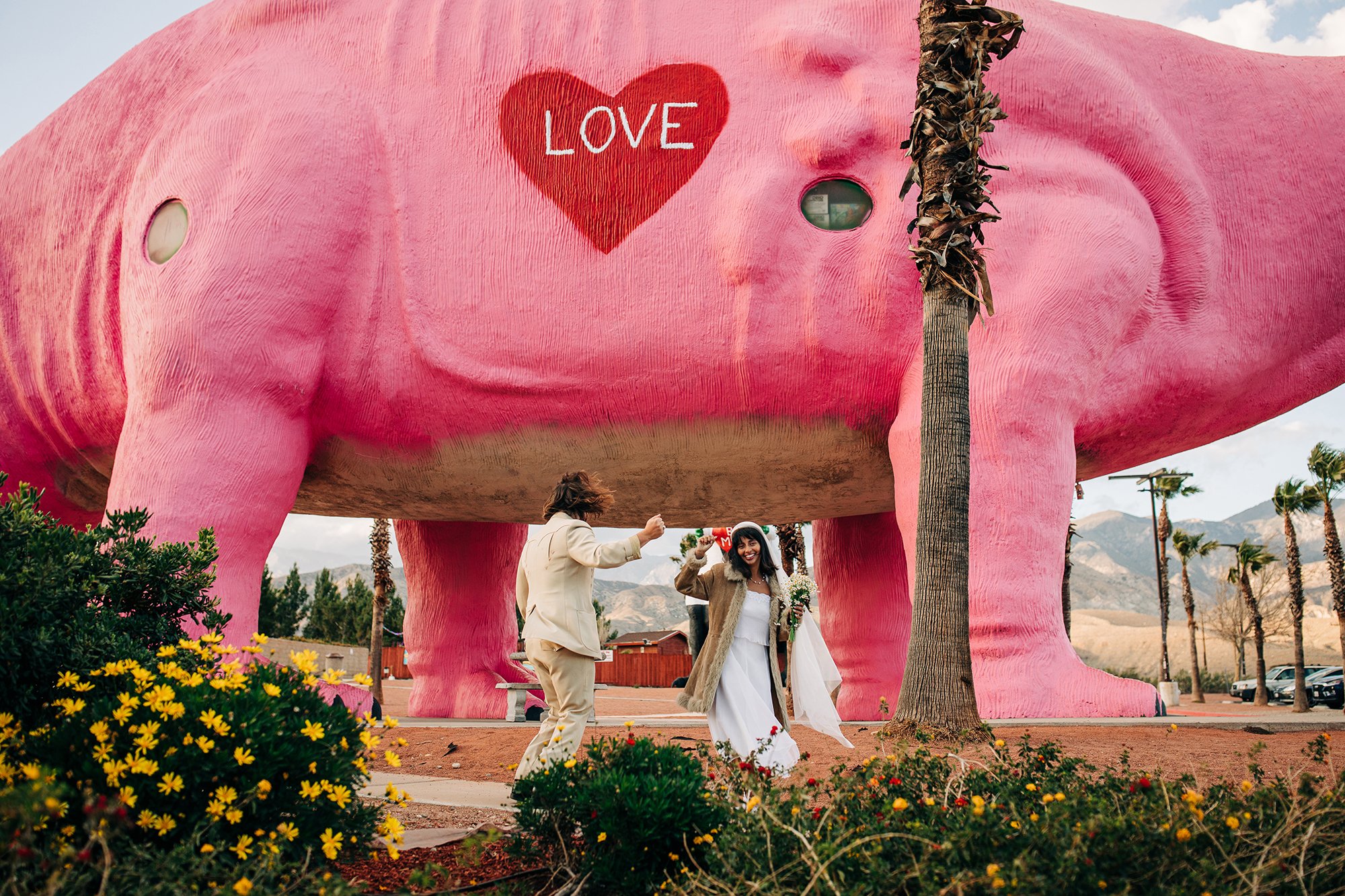 Zac and Val dance together in front of a pink dinosaur.