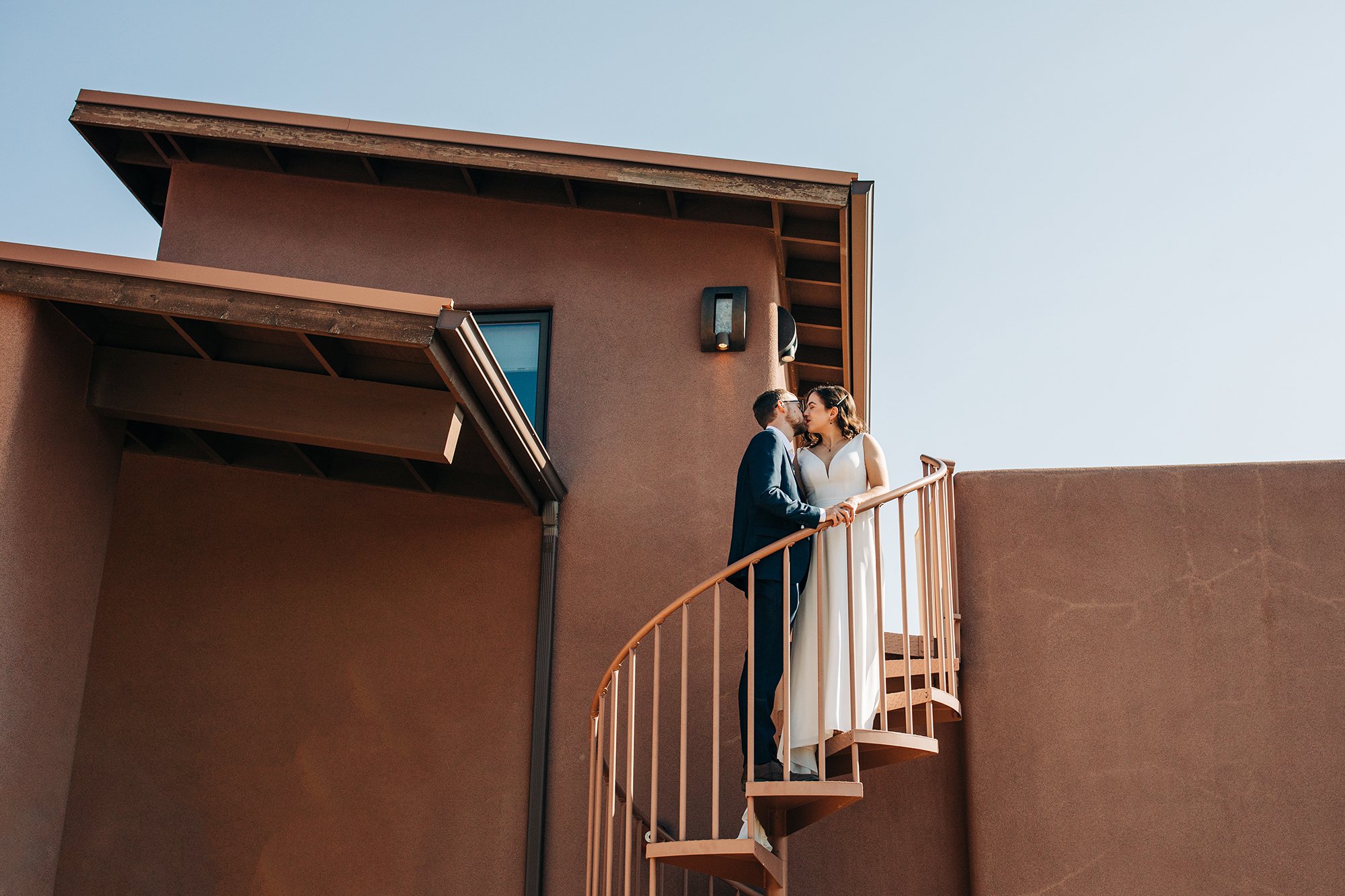 A couple stands on the stairs of their Airbnb in Sedona. 