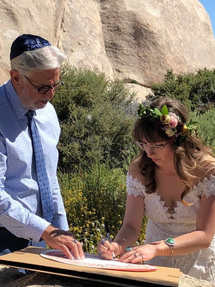 Diana signing a ketubah with the Rabbi during her Jewish elopement.