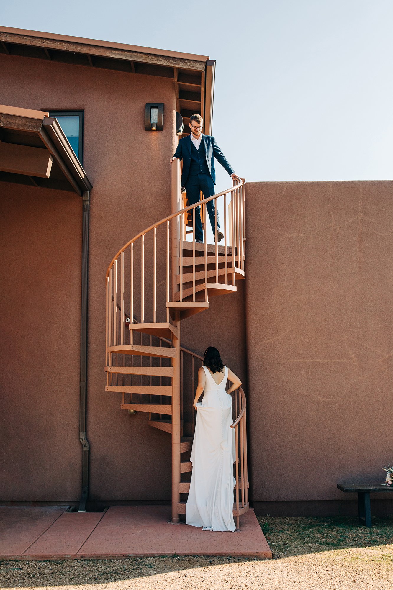 Matthew descends the stairs to meet his bride, Stephanie, wearing a lovely white dress during her Sedona wedding