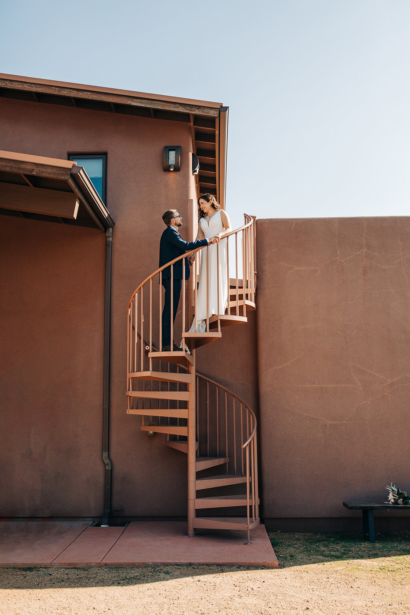 Wedding couple, Stephanie and Matt, pose for a photo on the stairs ahead of their Sedona elopement wedding