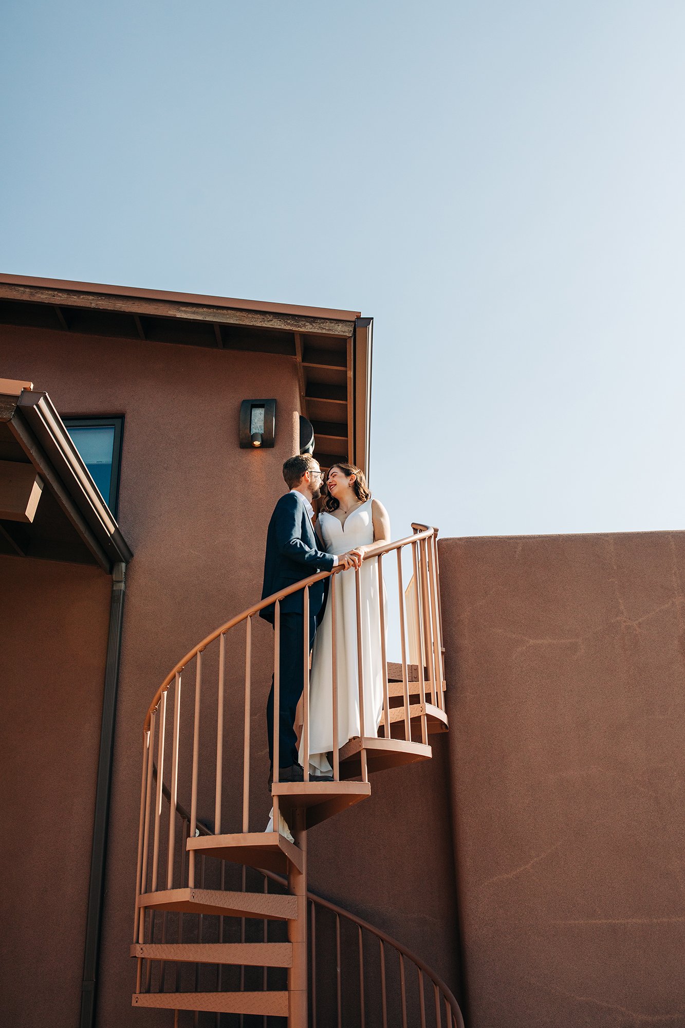 Newly wed couple, Stephanie and Matthew, get close on a spiral staircase for their outdoor wedding in Sedona Arizona