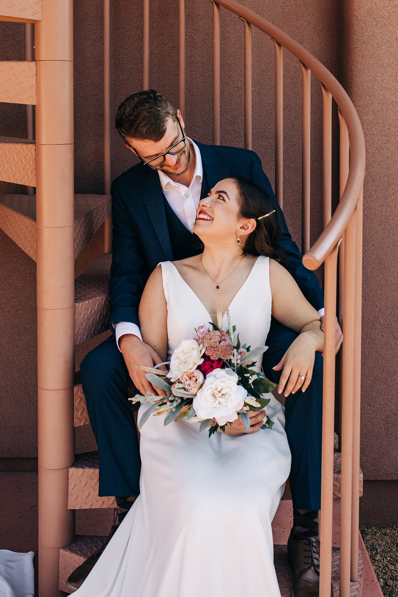 A close-up of Matt wearing a suit, snuggled up to his bride, Stephanie, during their Sedona elopement