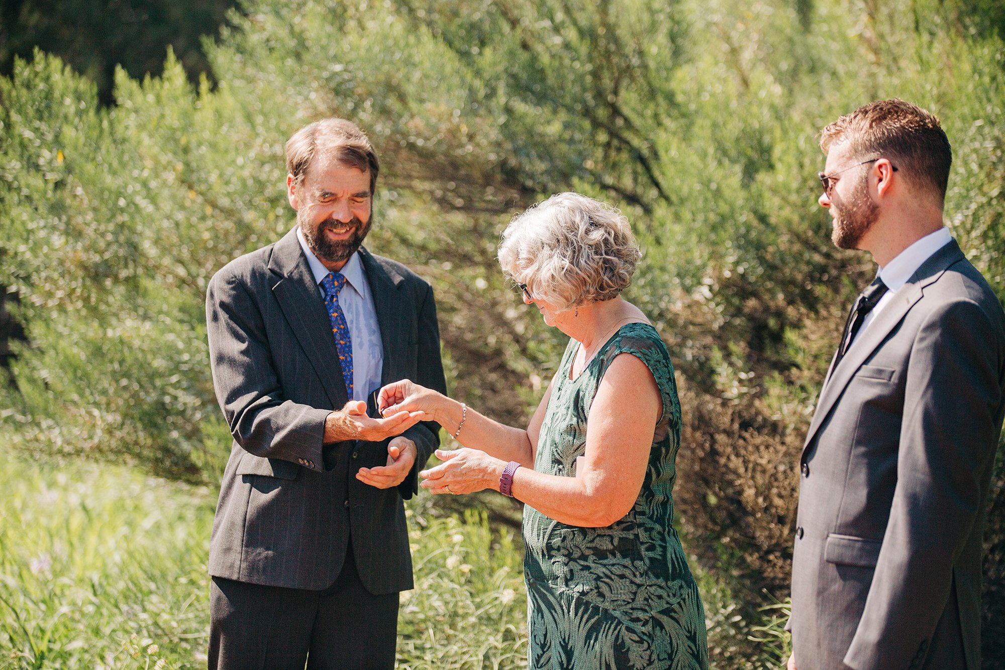 The groom's parents smile at eachother during the ring warming ceremony at this Sedona elopement