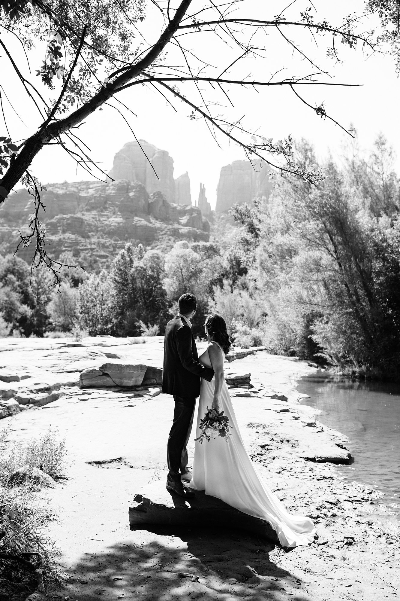 Stephanie and Matthew hold eachother close and look out at the Sedona landscape in this black and white wedding photo