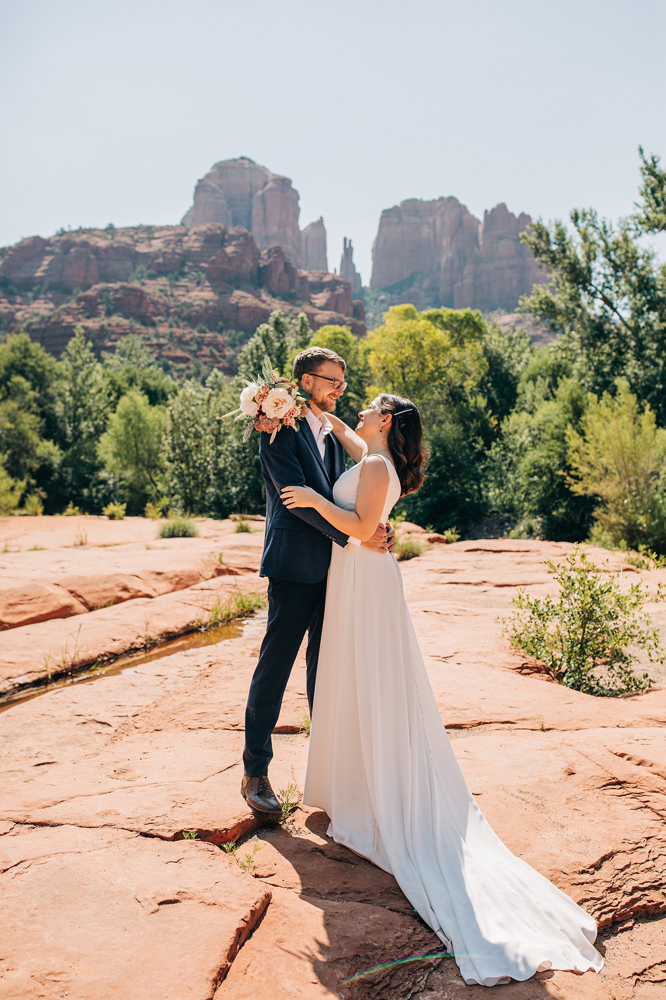 With boquet in hand, Stephanie and Matt smile widely at each other during their Sedona wedding day
