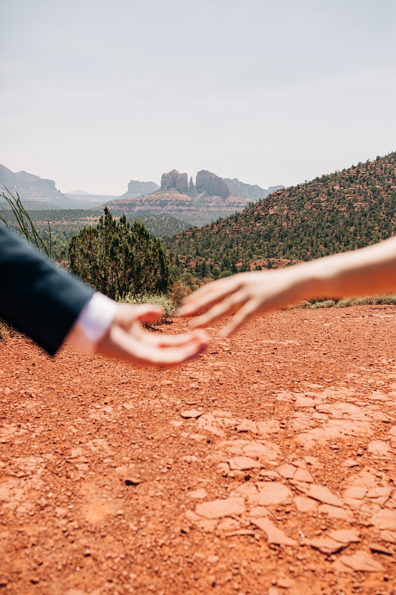 Newly wed couple reaches out to each other in this artistic Sedona wedding photograph