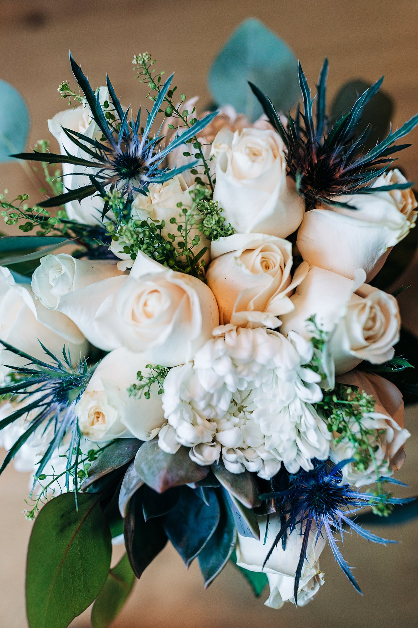 A white, green, and blue wedding bouquet.