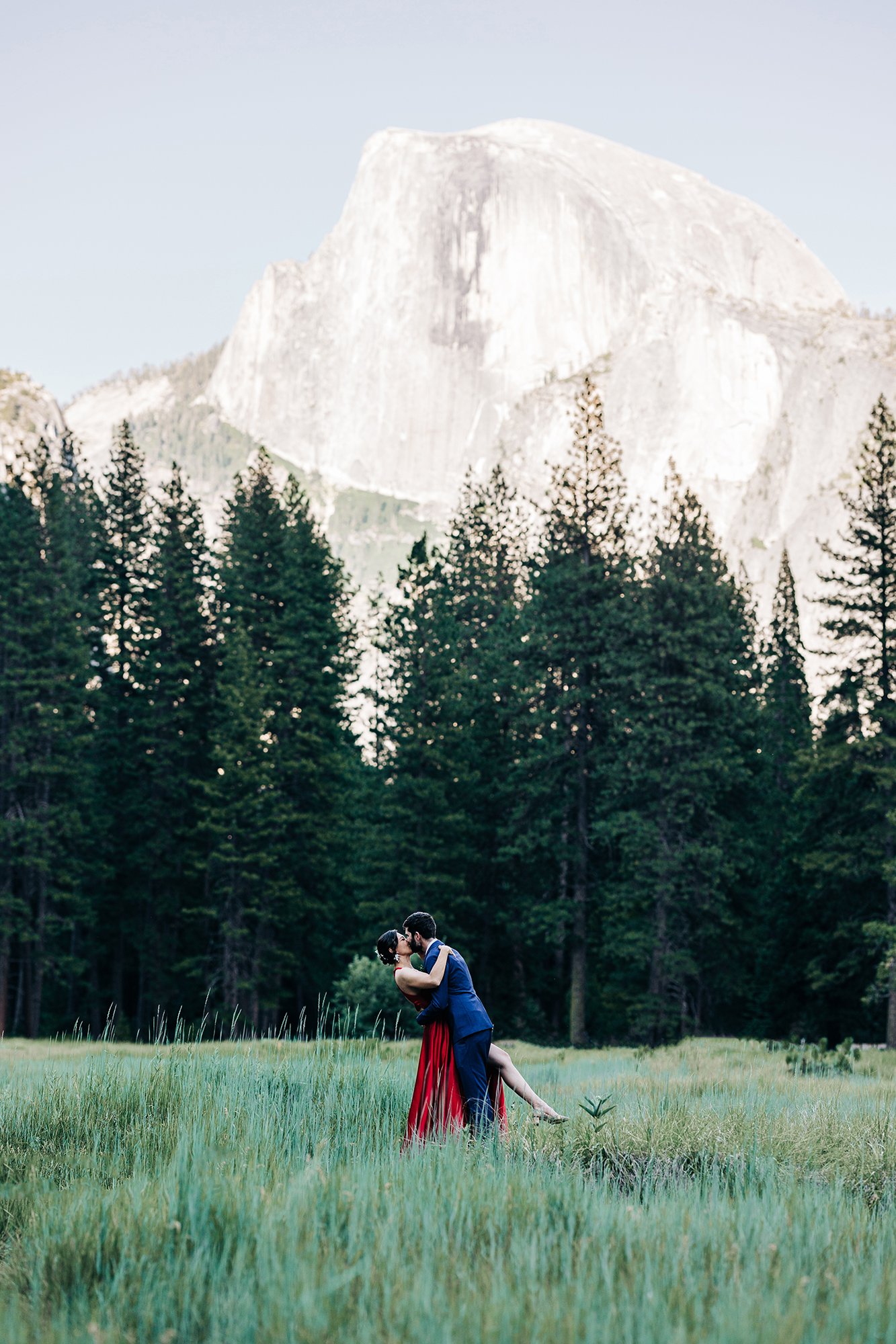 Yooree and Jarrod kiss under Half Dome in Yosemite.
