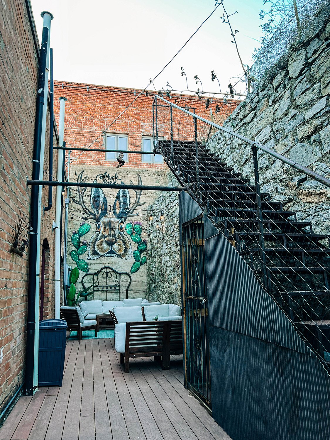 A small patio with a jackalope mural in a hotel in Bisbee, Arizona.