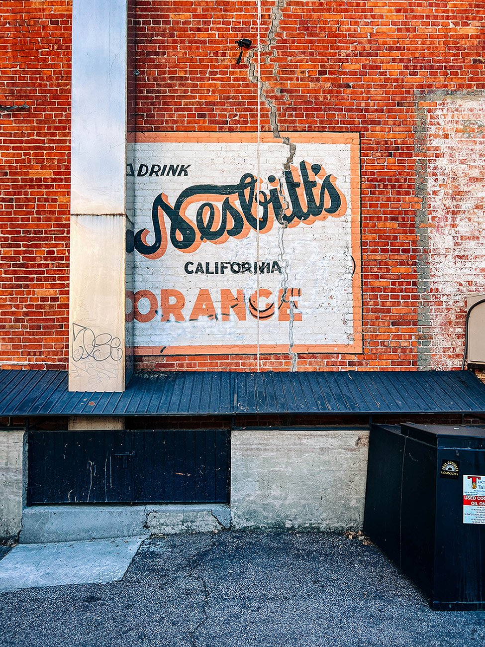 A retro sign painted on an old brick wall.