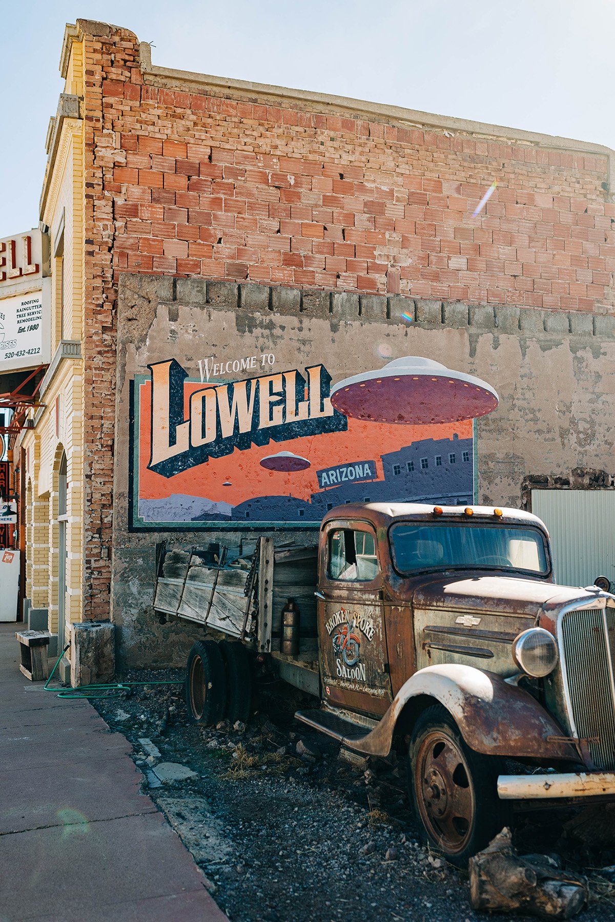 A retro car sits in front of a welcome mural in Bisbee, Arizona.