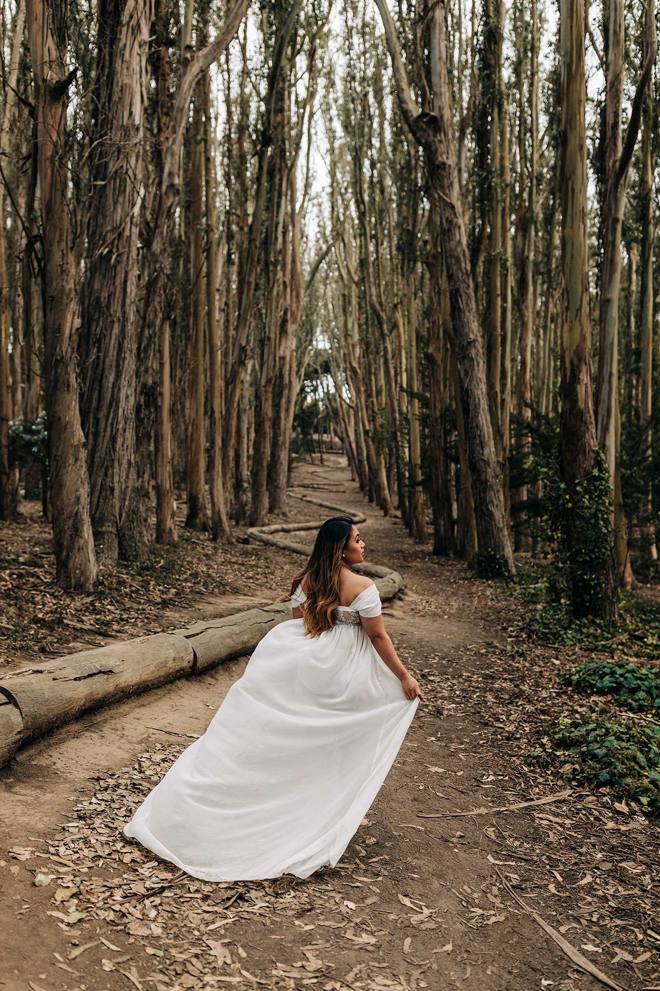 A pregnant woman walks through an iconic forest in San Francisco.