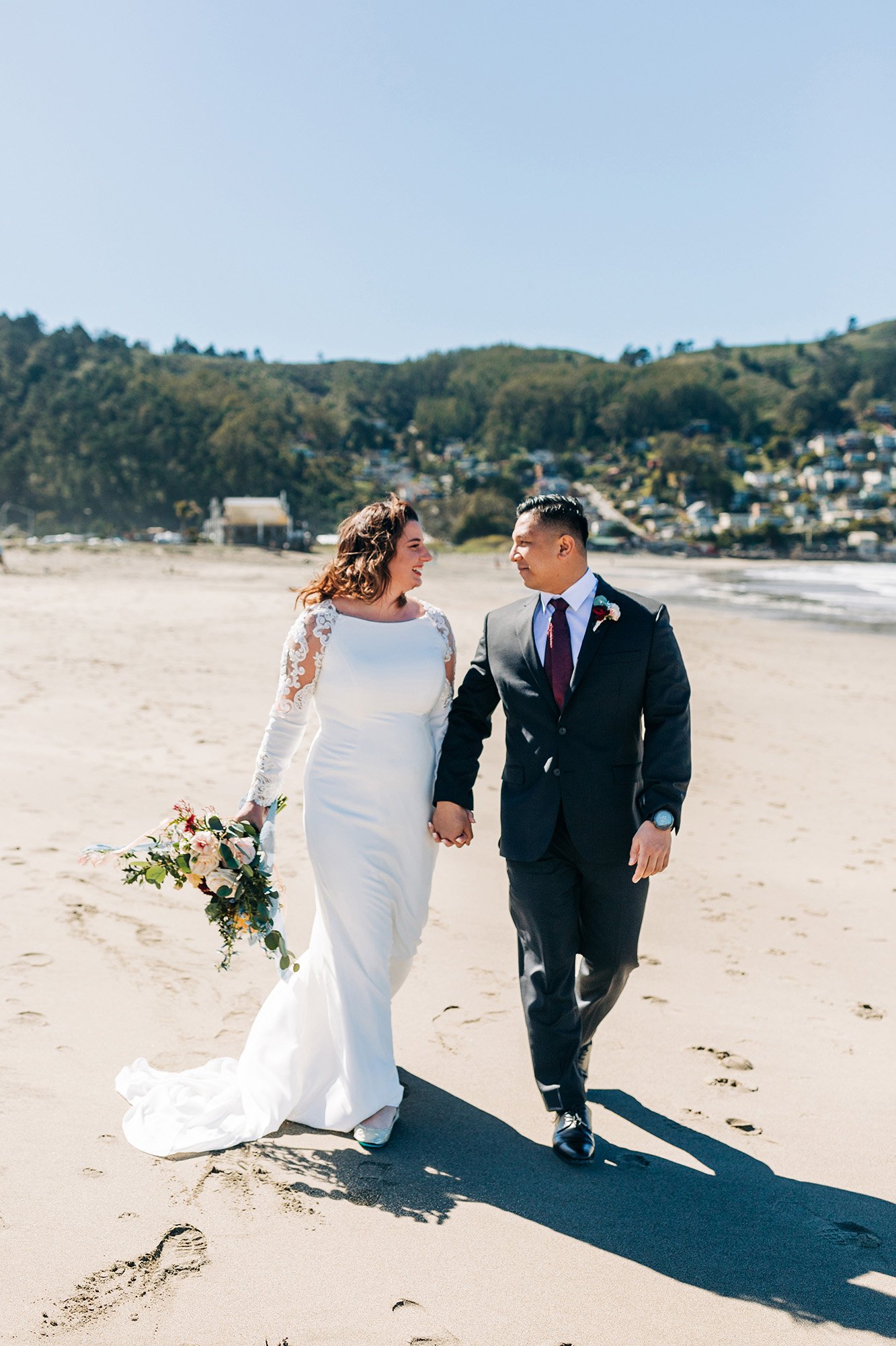 Ashley and Paul walk together on the beach in San Francisco, California