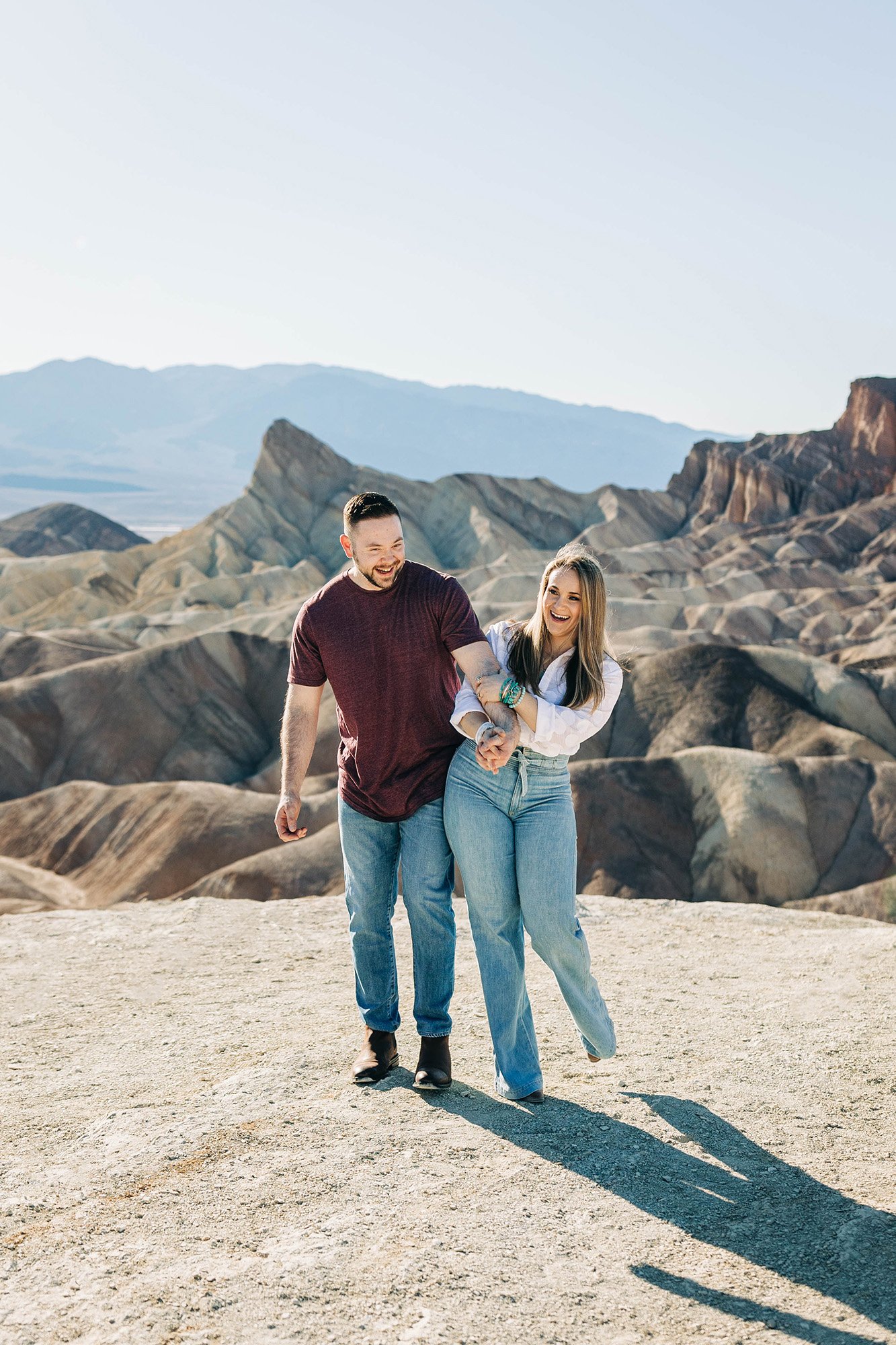 A couple walks in front of a beautiful view in Death Valley National Park.