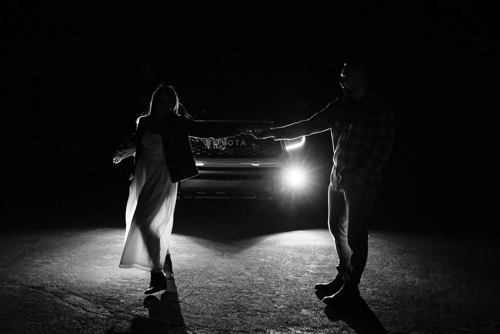 Alex and Aly dance in front of the headlights of their truck.