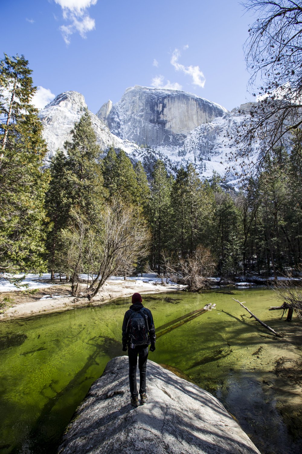 A person stands in front of Mirror Lake in Yosemite.