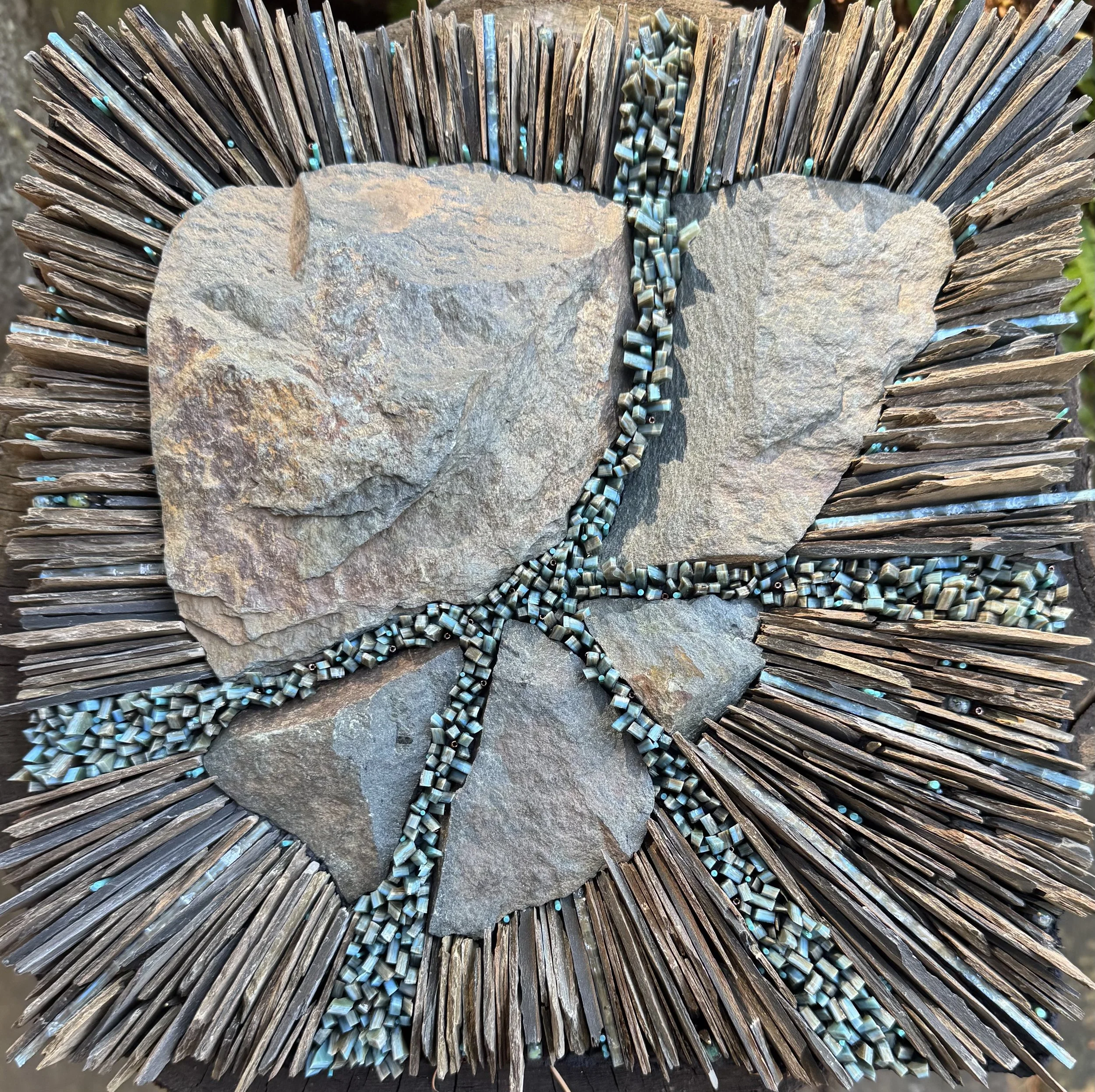 "Rodinia" - Catoctin Greenstone, stained glass, glass rods and beads, slate and muscovite mica. Tesserae embedded in thinset on waterproof backer board. 14"x14"x1". (Available)