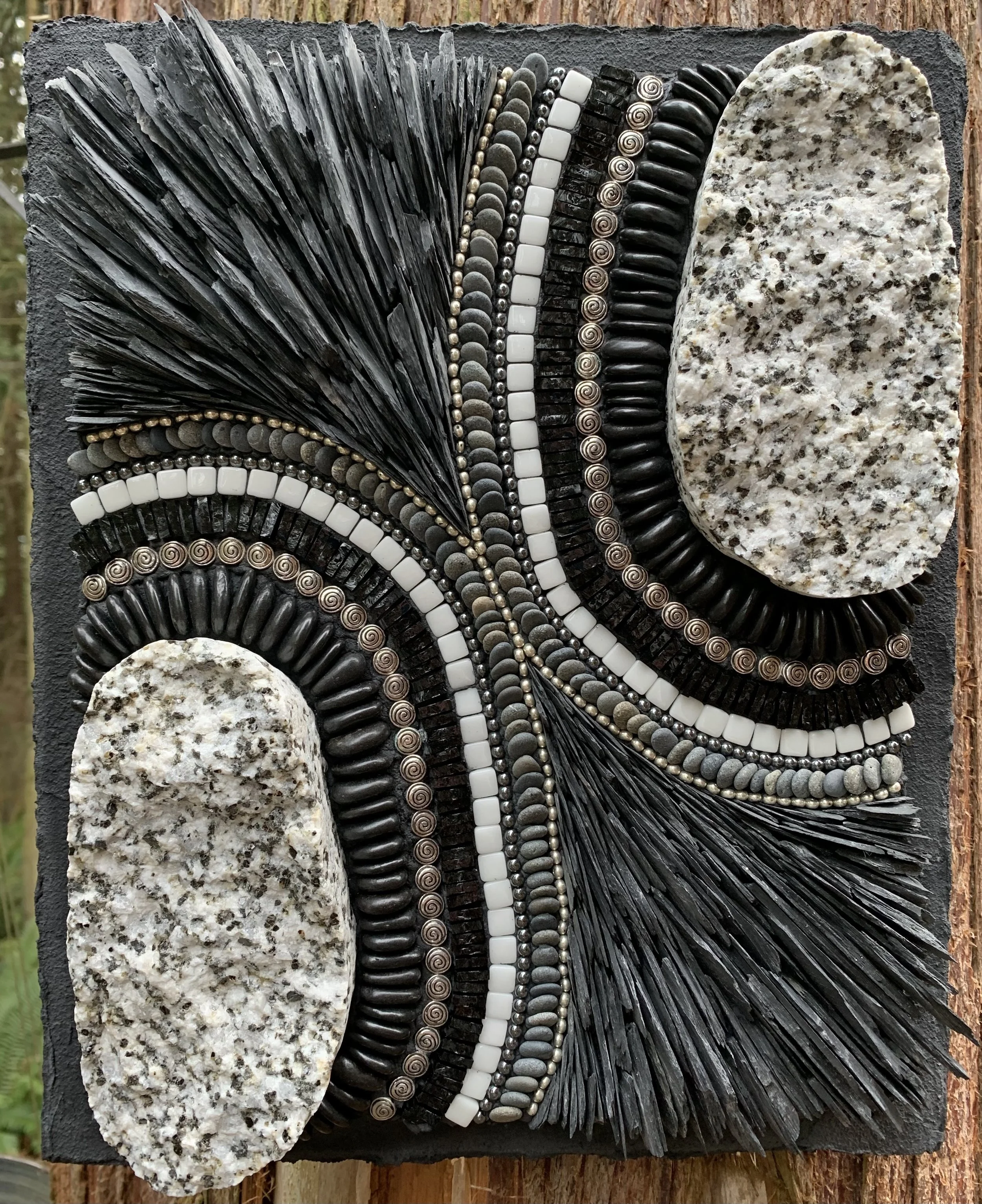 "Granite Twins" - Split cobble of granite from North Beach, Port Townsend, WA; brought to the shores of the Salish Sea from points north during the last glacial ice age. Slate, black river pebbles, beach pebbles, glass tiles, stained glass, metal and
