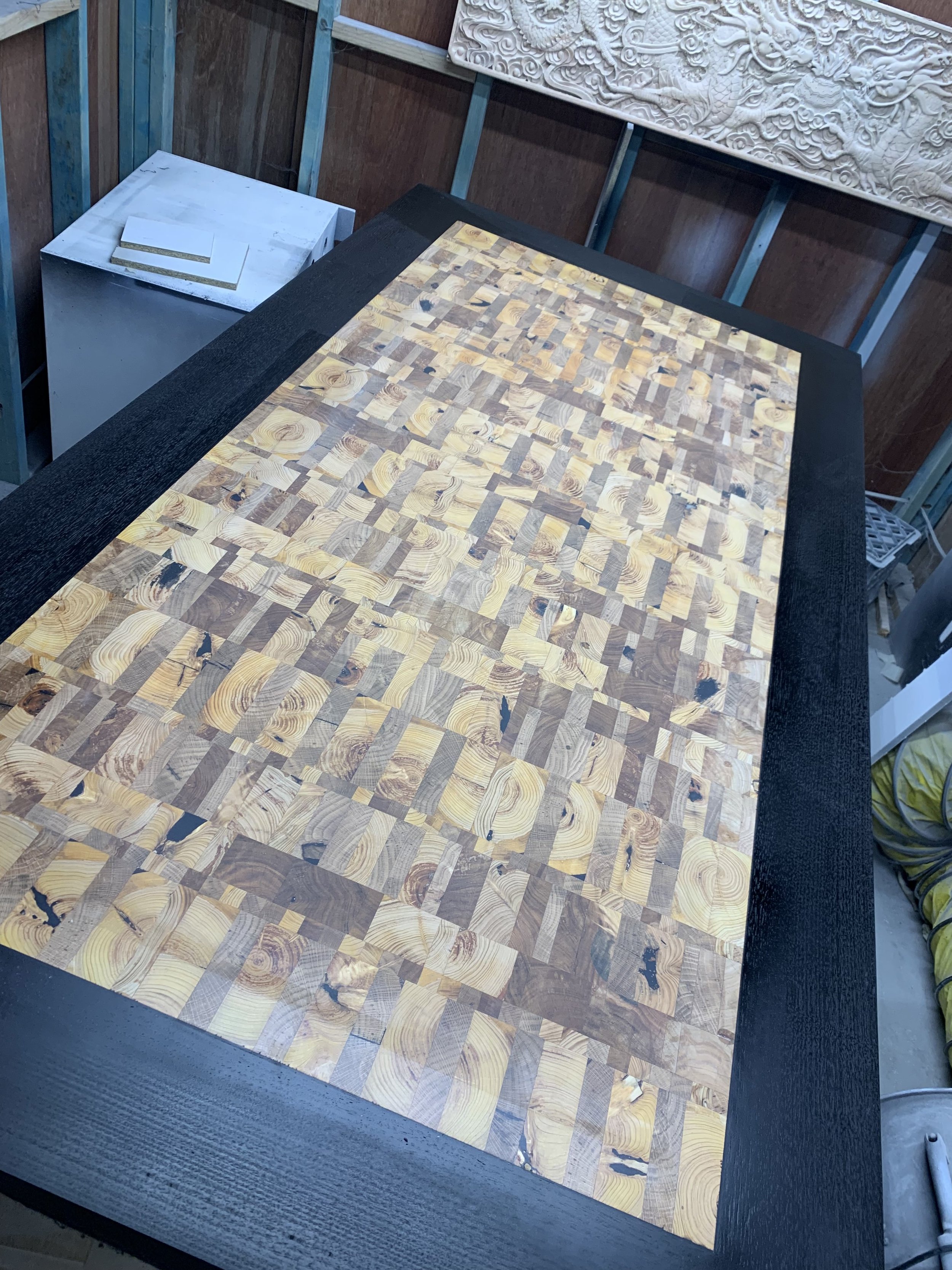 Wooden table with intricate patterned surface and black border