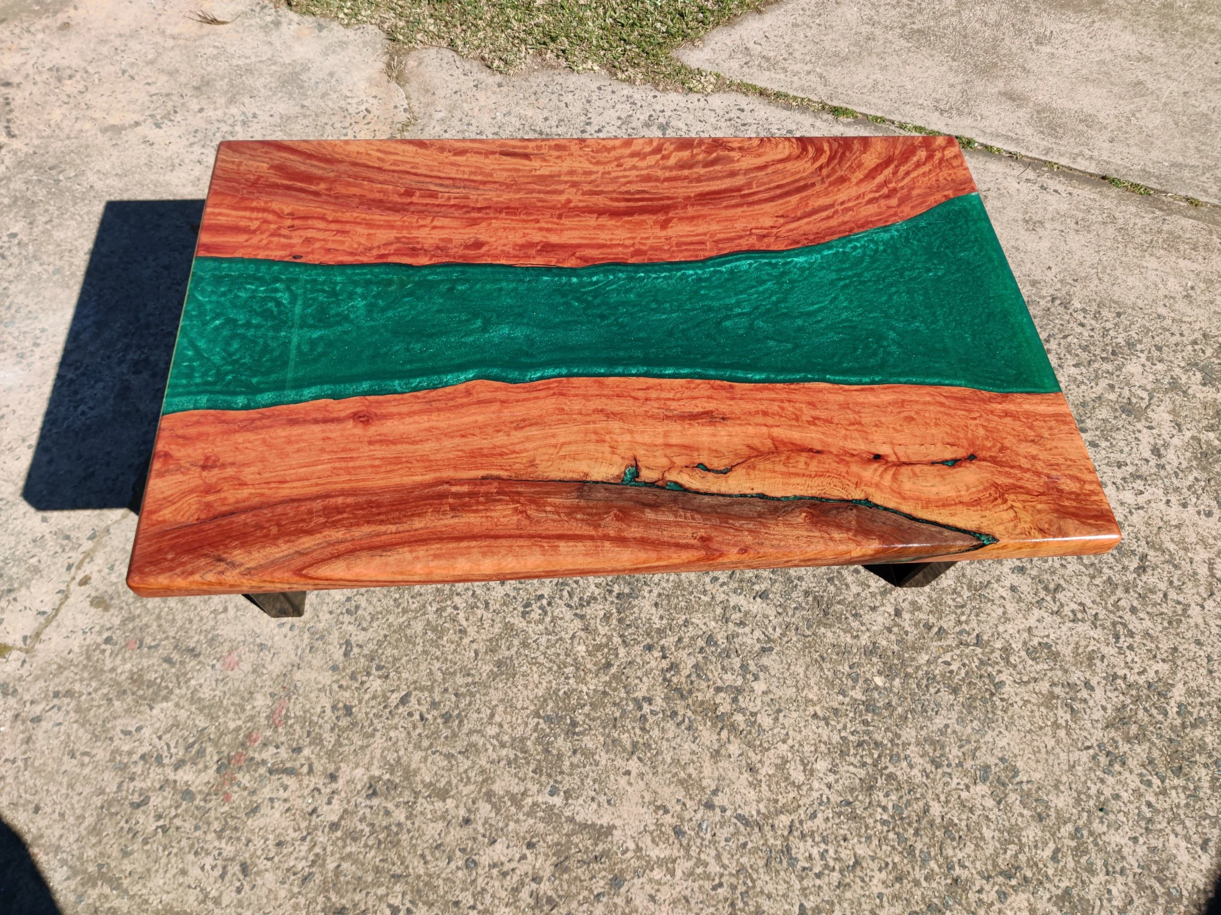 river resin coffee table, with emerald resin and red box timber and a veneer shelf underneath.