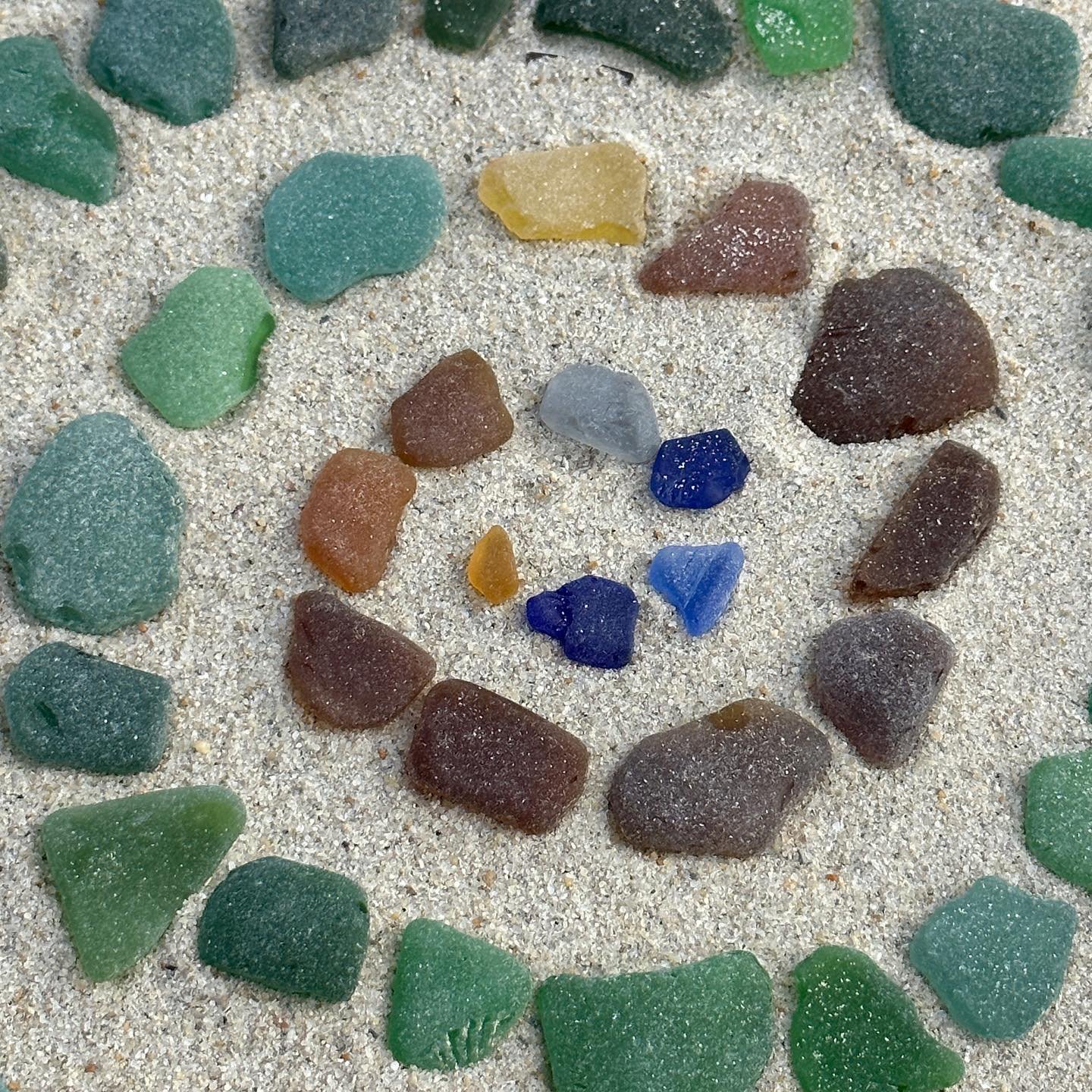 sea glass from sicily and scotland, shells from wales, rocks from turkey. spiralling together on my new local beach in west aus :)