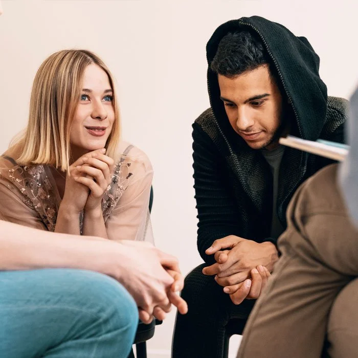 man and woman sat with other people talking