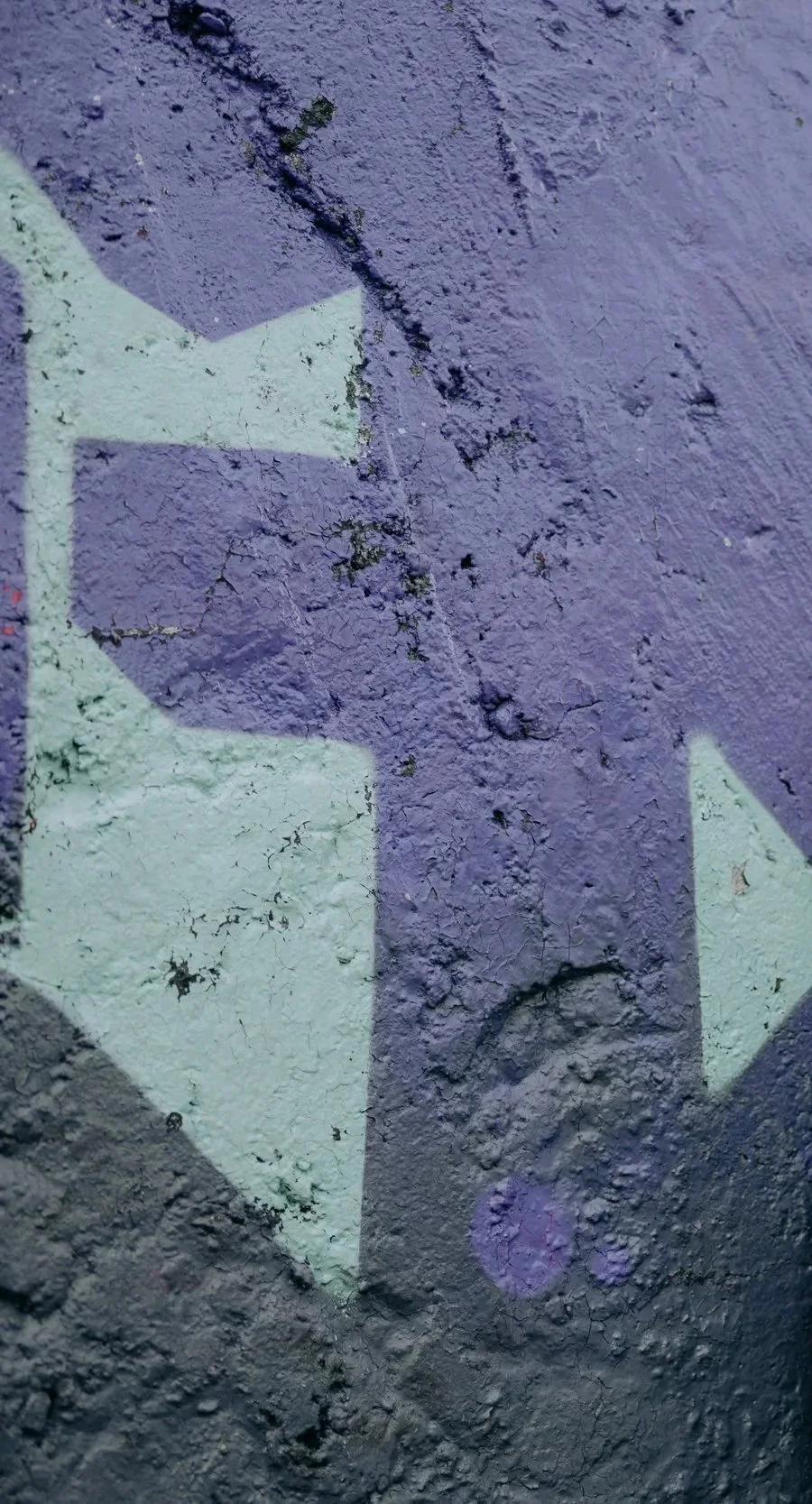 purple graffiti on a concrete wall