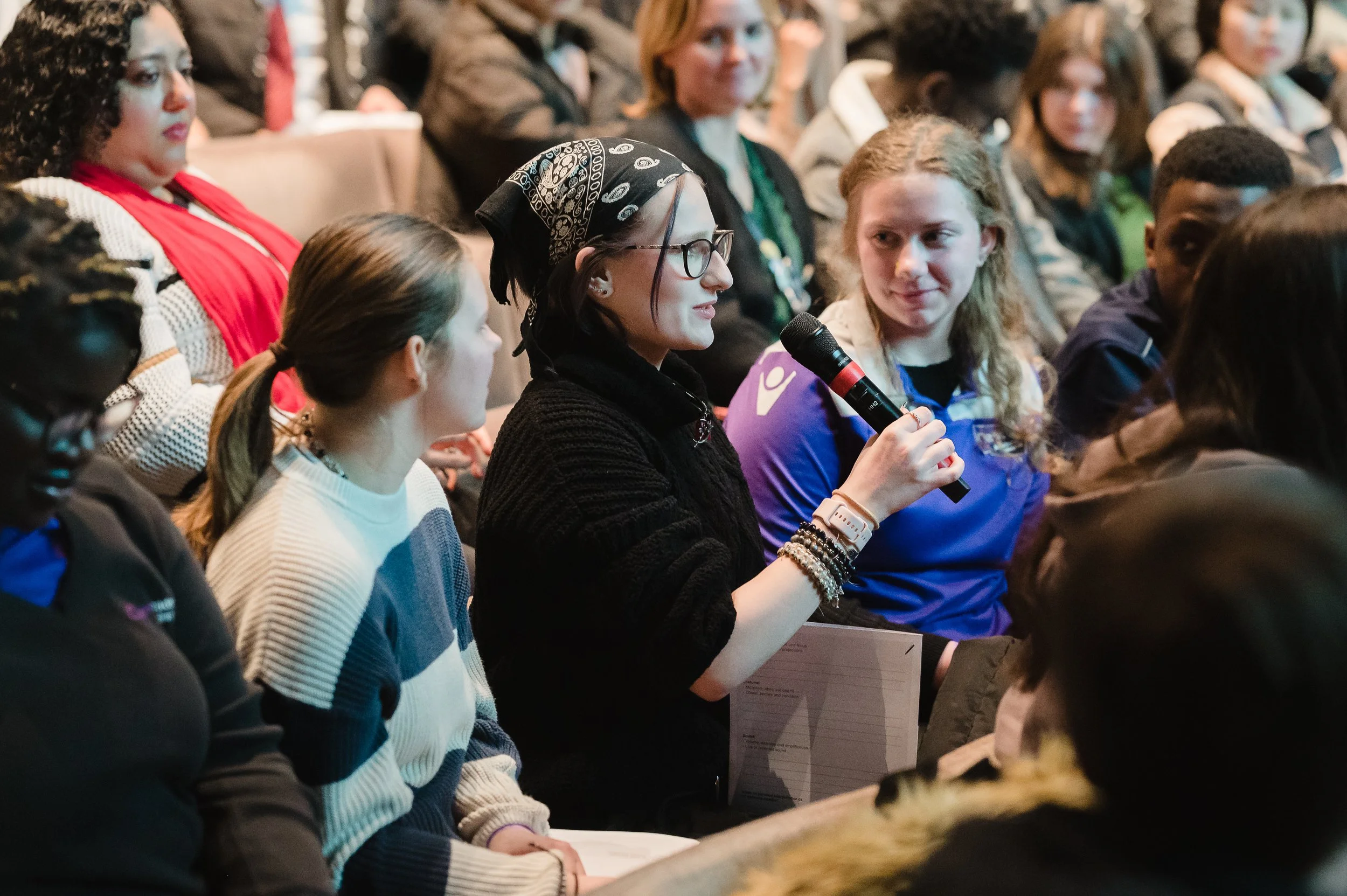 A student in the audience holding the microphone to ask a question.