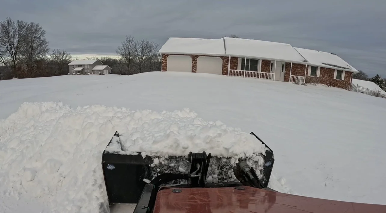 Mid-Country Tree Services using a box plow to push snow off a driveway in Linn, Missouri, ensuring safe, clear access during winter conditions.