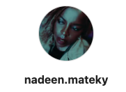 Portrait d'une femme avec une expression sérieuse, coiffure colorée et maquillage distinctif.