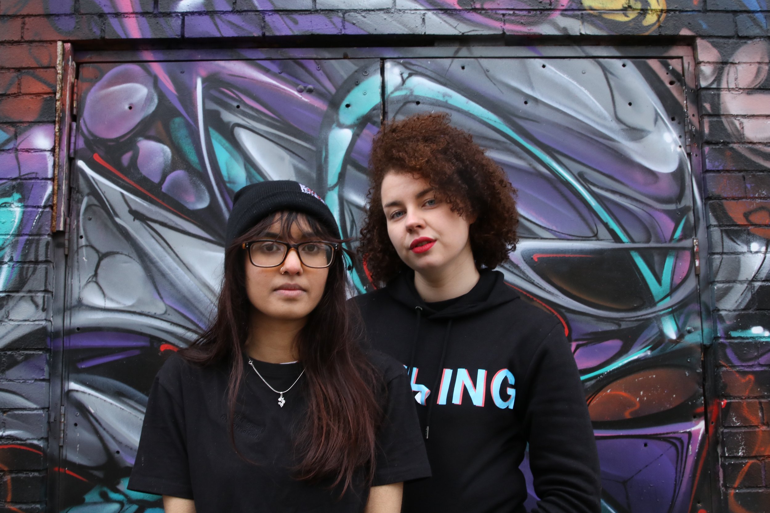 Two girls wearing a beanie and hoodie which says 'nothing' across the front.