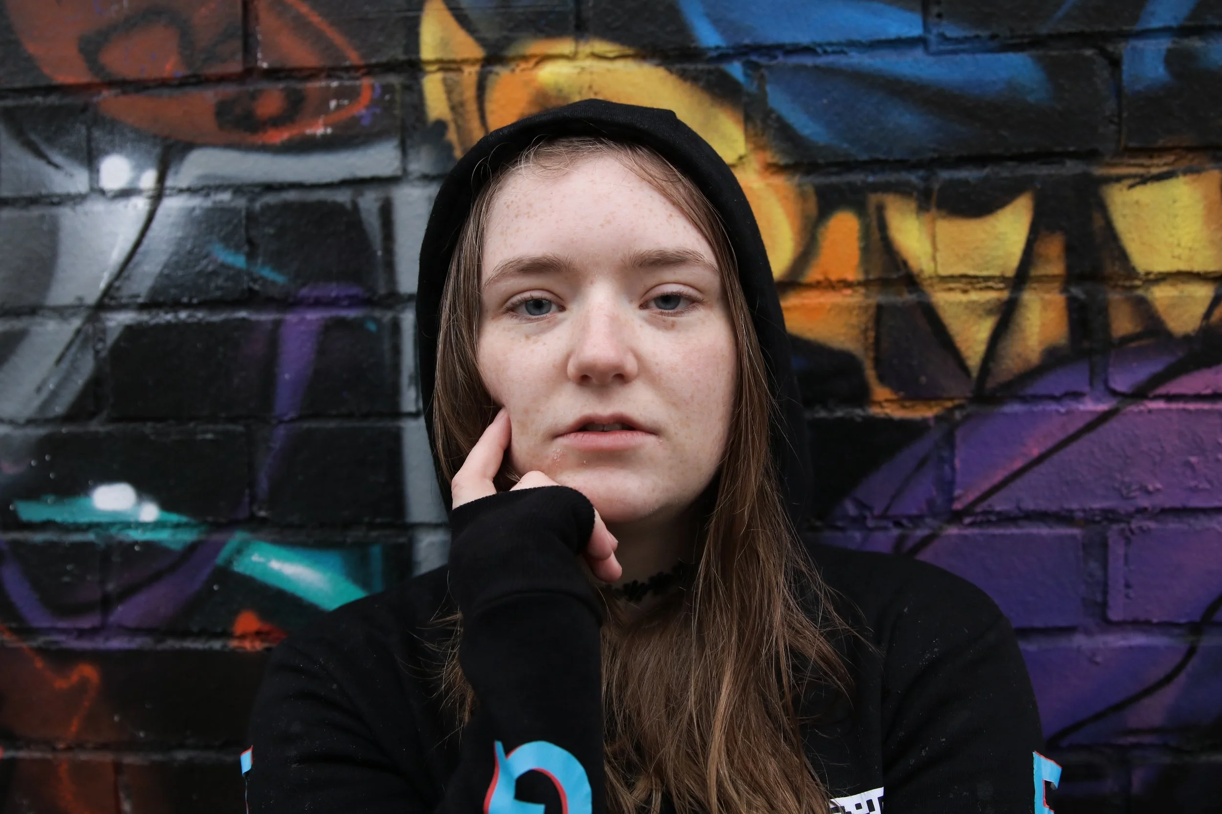 Girl wearing a beanie and hoodie which says 'nothing' along the sleeves.