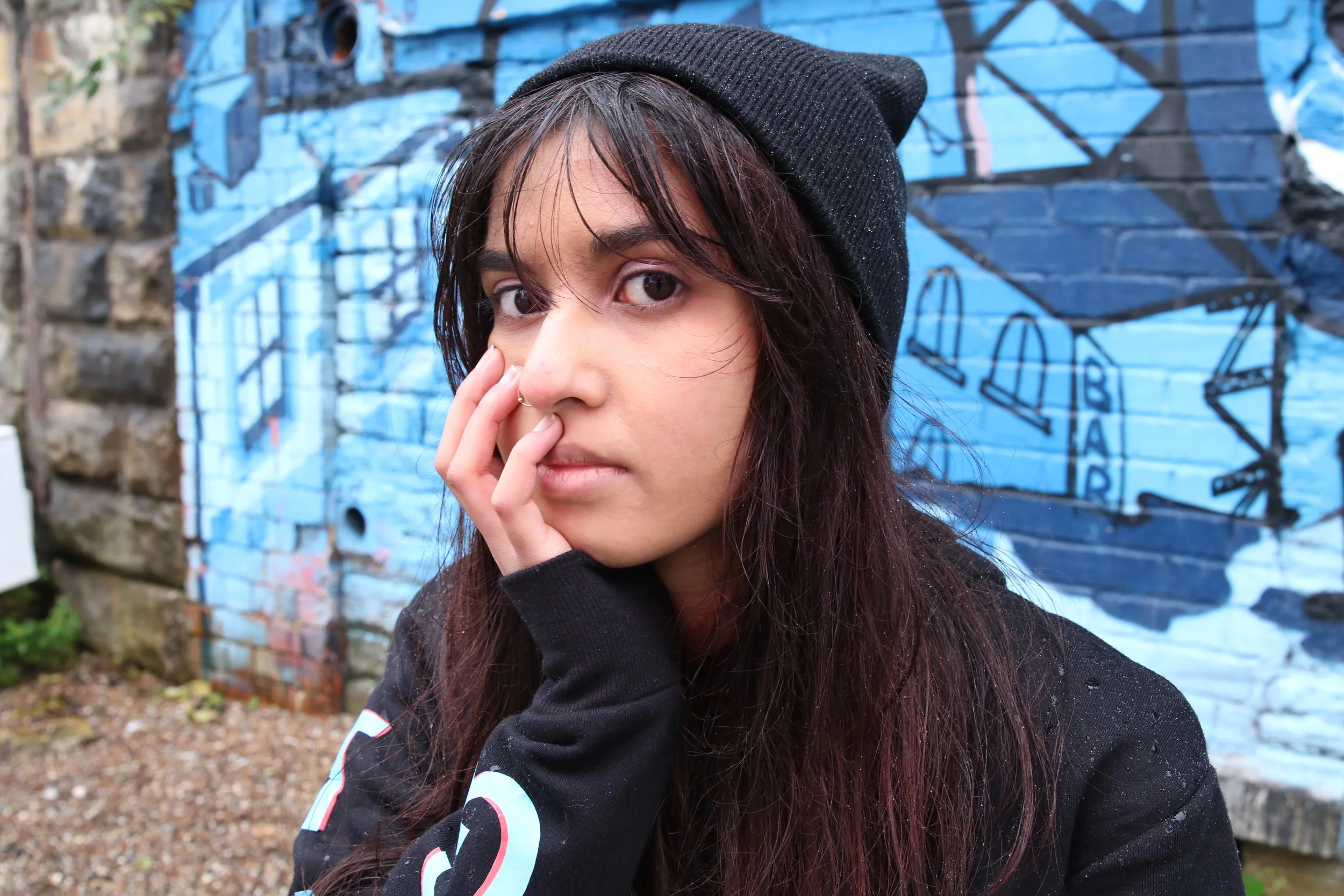 Girl wearing a beanie and hoodie which says 'nothing' along the sleeves.