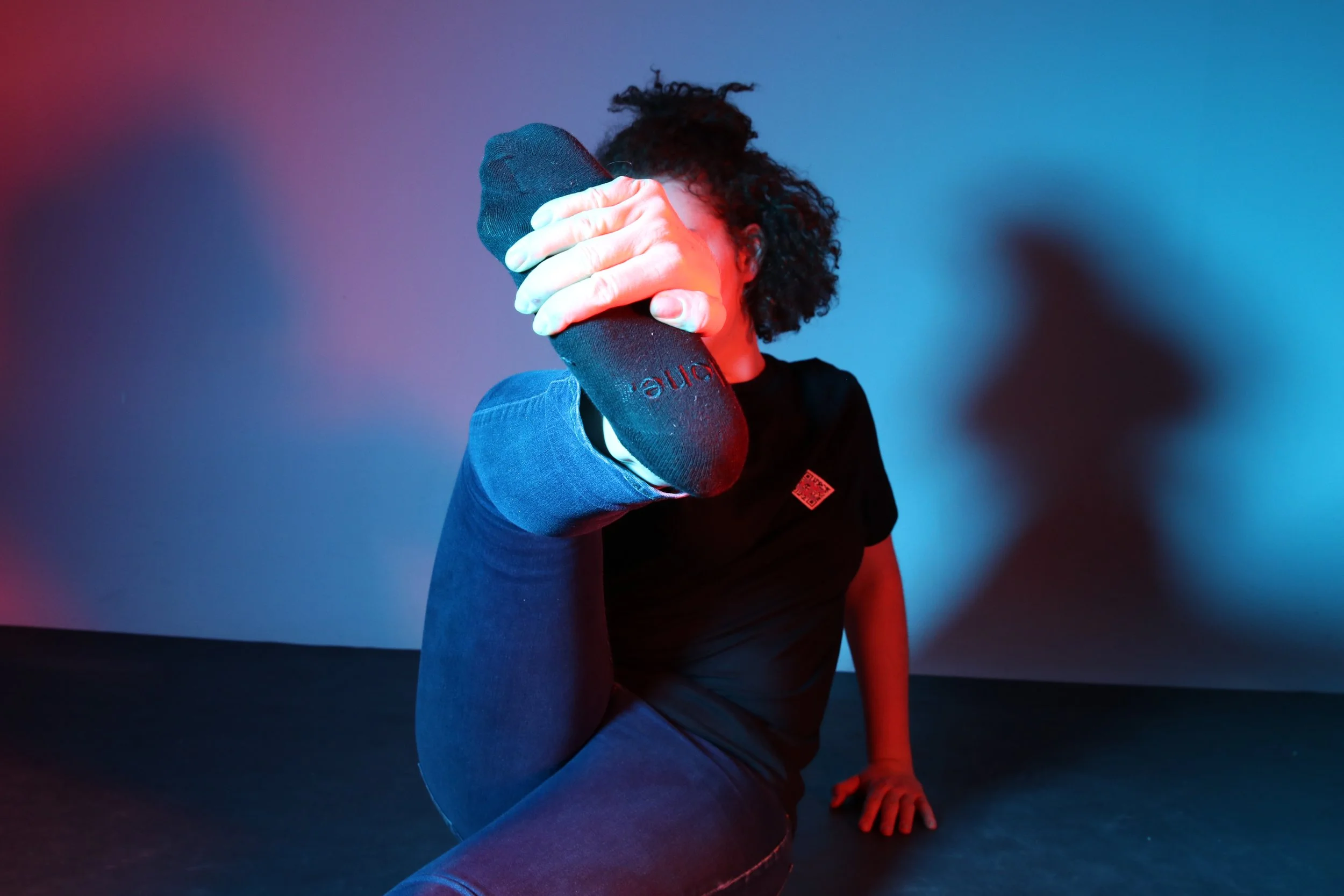 Girl wearing a tshirt with 'R' QR code logo and socks which have text 'alone' embroidered.