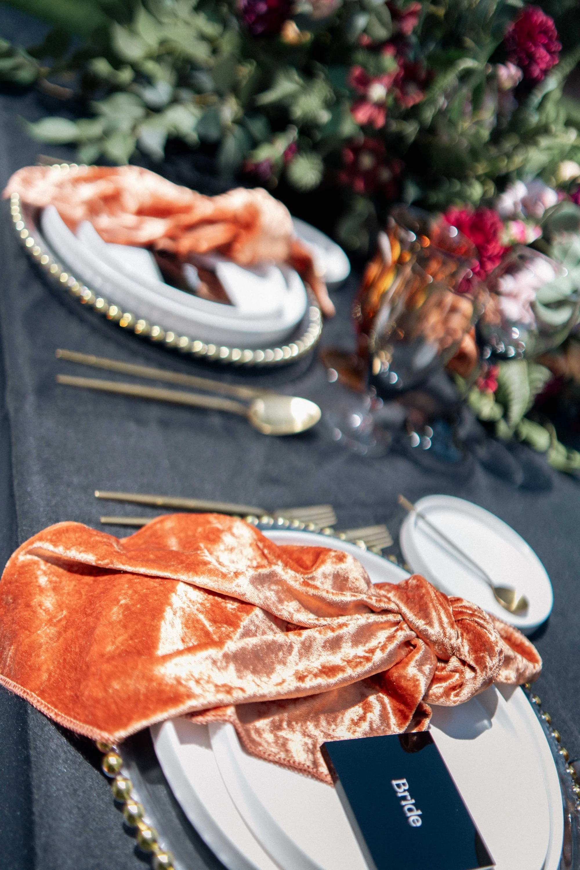 Flatlay of velvet napkins and gold flatware styled for an elegant reception table.