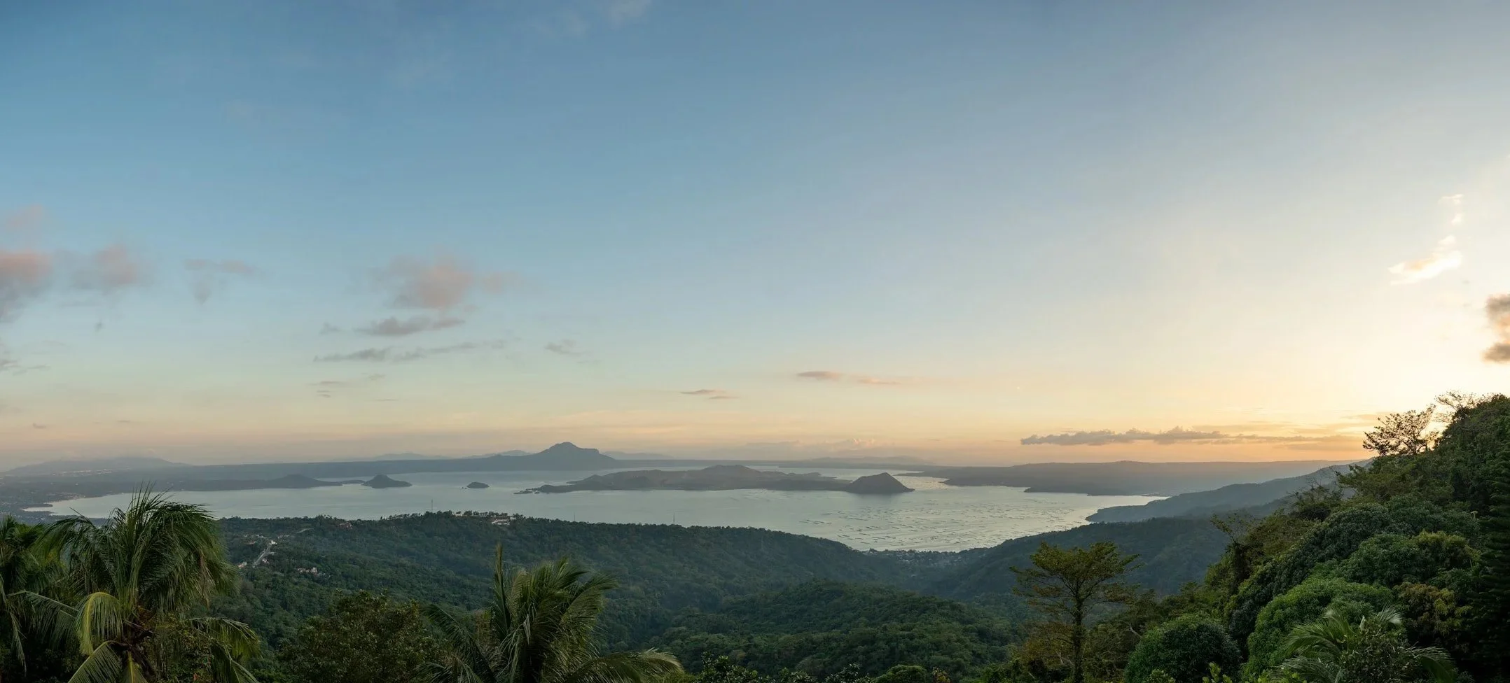 A wide landscape shows layered hills and distant water under a fading sky, inspired by a Fragmented Memories prenup photographer.