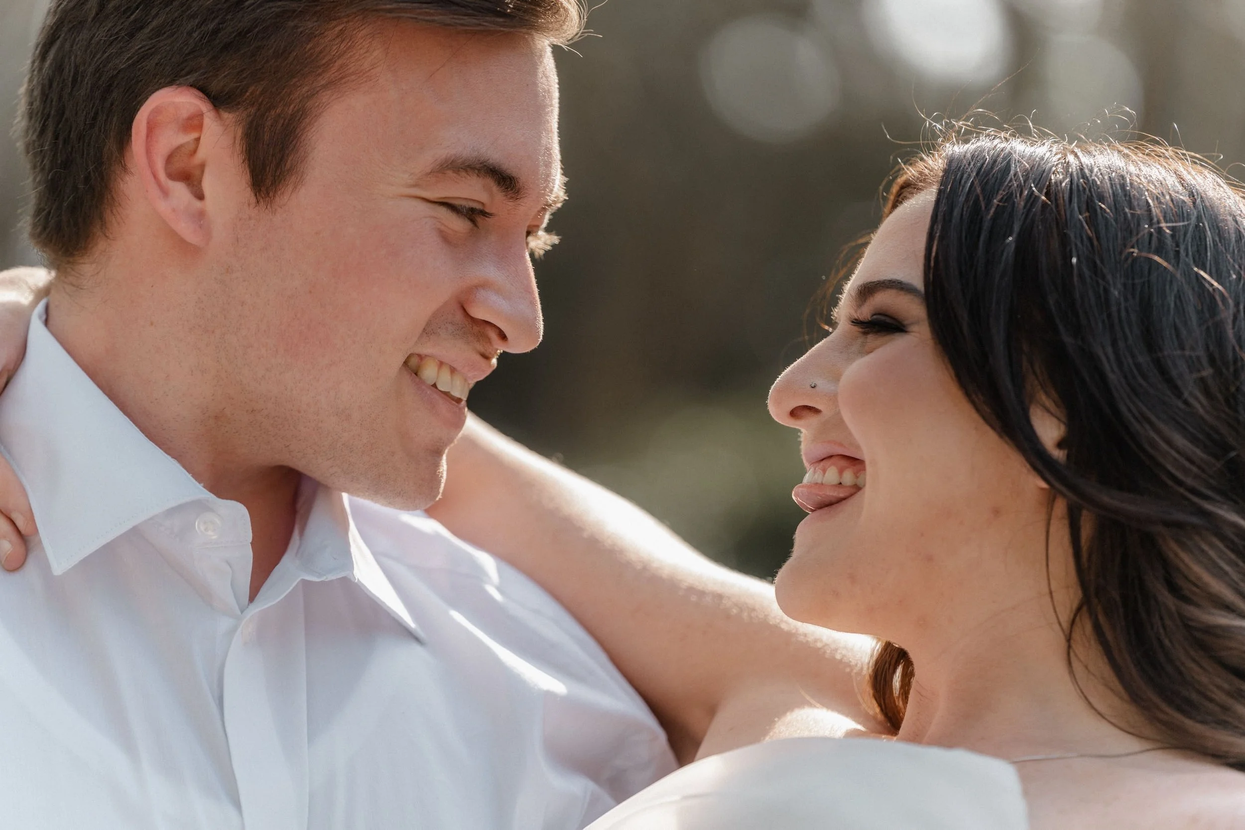 Couple laughing close together, sunlight highlighting their expressions, inspired by Los Angeles wedding photography