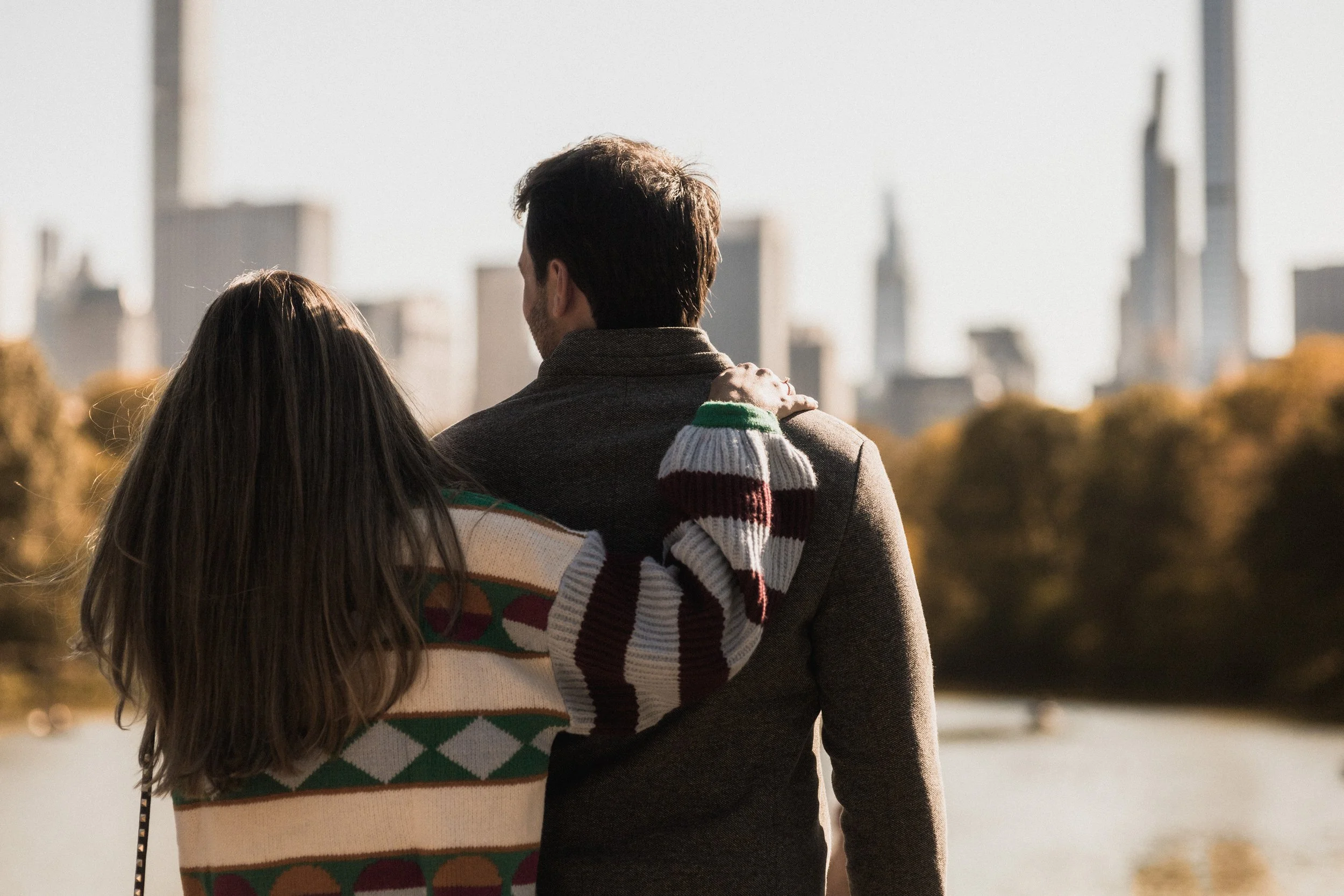 Couples gazing at NYC skyline after proposal in Central Park
