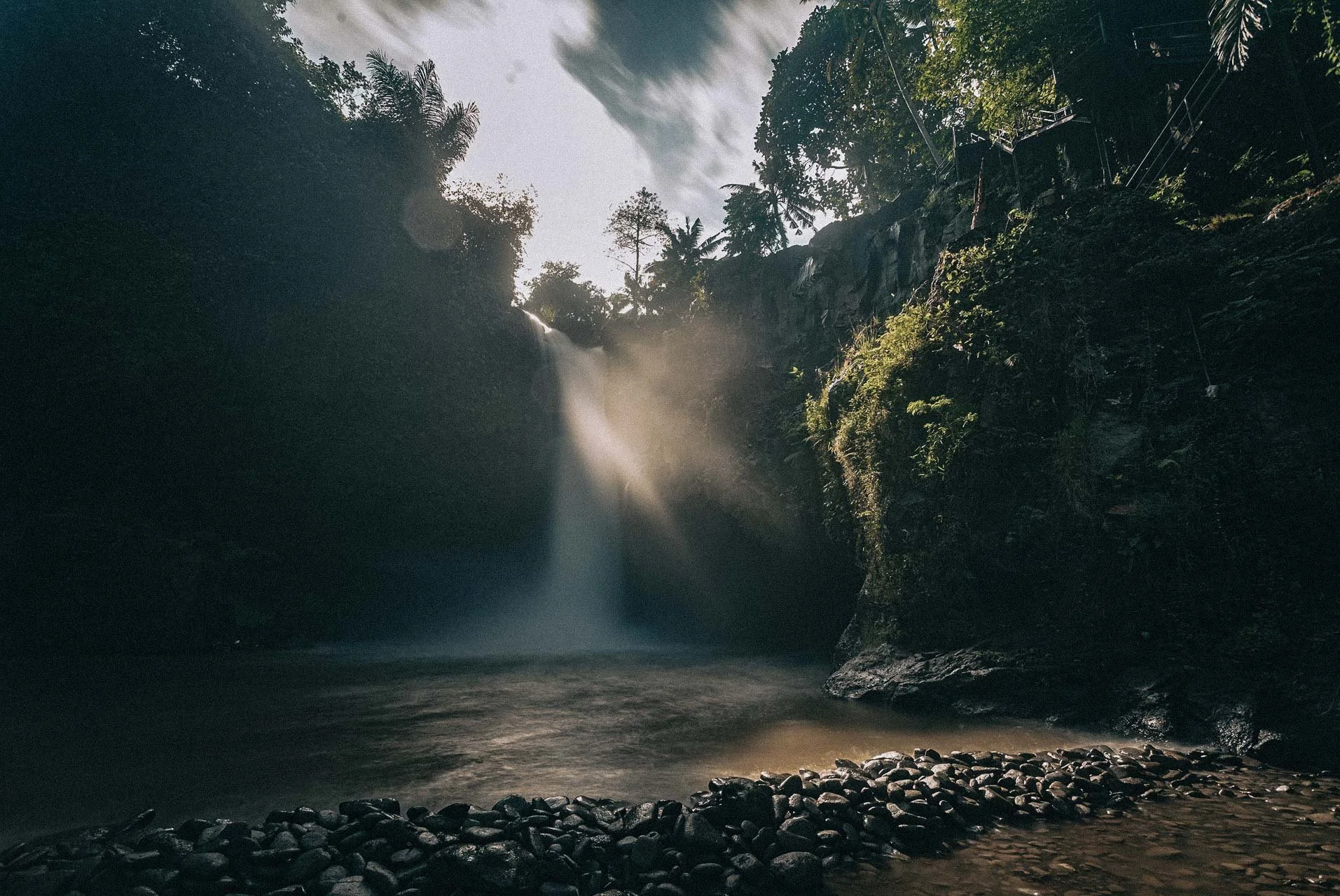Waterfall light cutting through the jungle mist, a cinematic frame held by an Hanging Gardens of Bali wedding photographer.