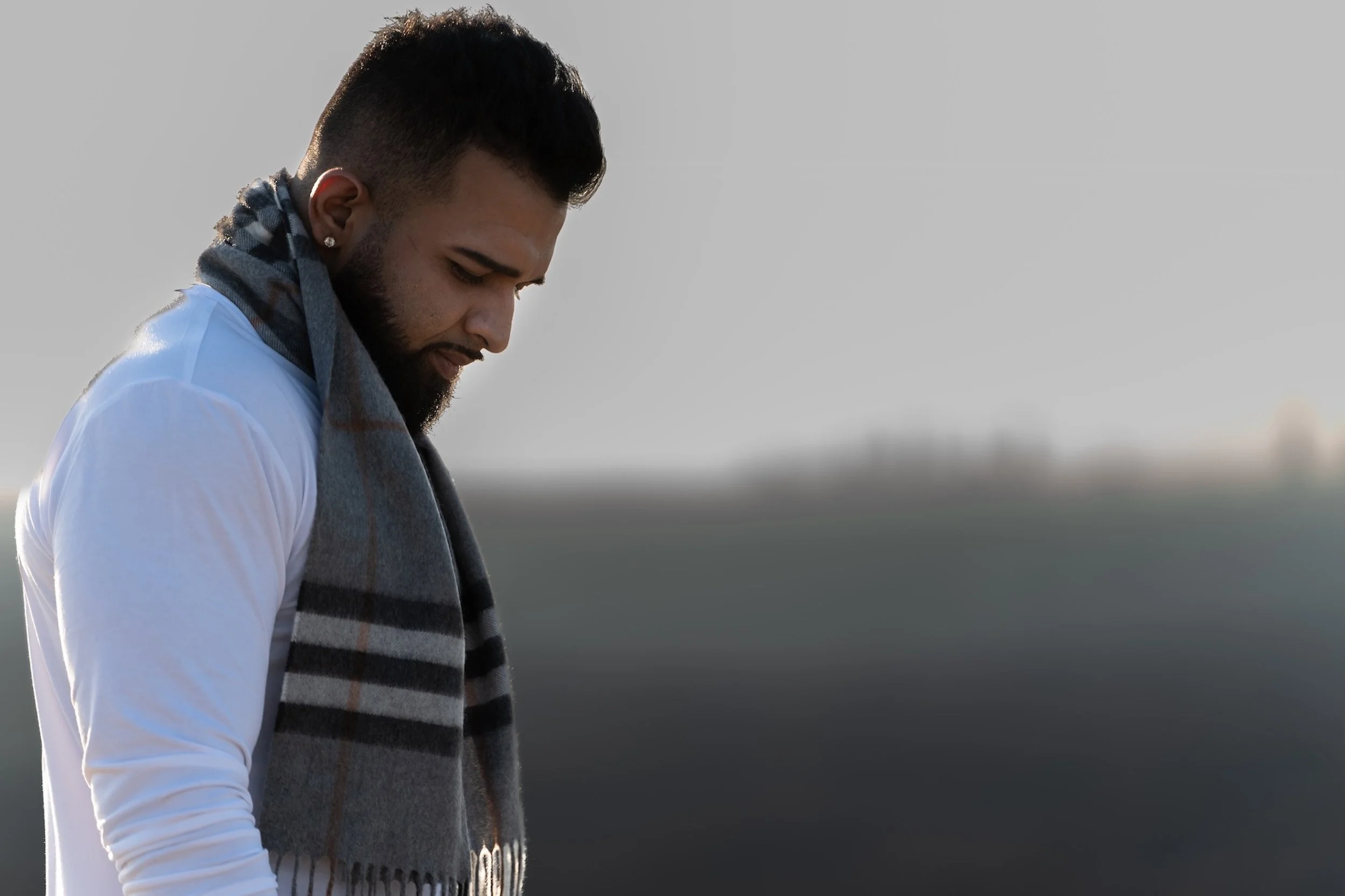 A man stands in quiet reflection, wrapped in a scarf, cinematic portrait photography by Bali photographer Caz Isaiah