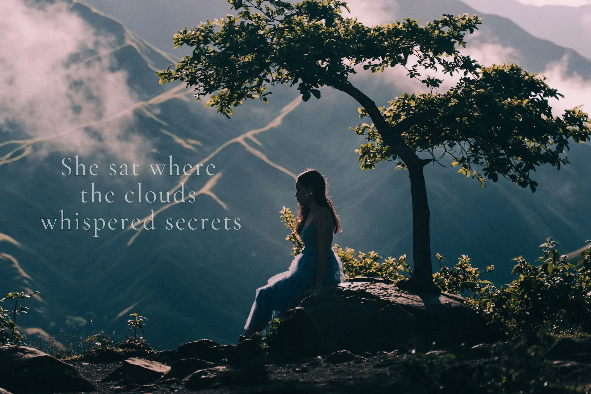 She sat beneath a lone tree, clouds drifting across the mountains in cinematic silence — Vietnam Wedding Photographer