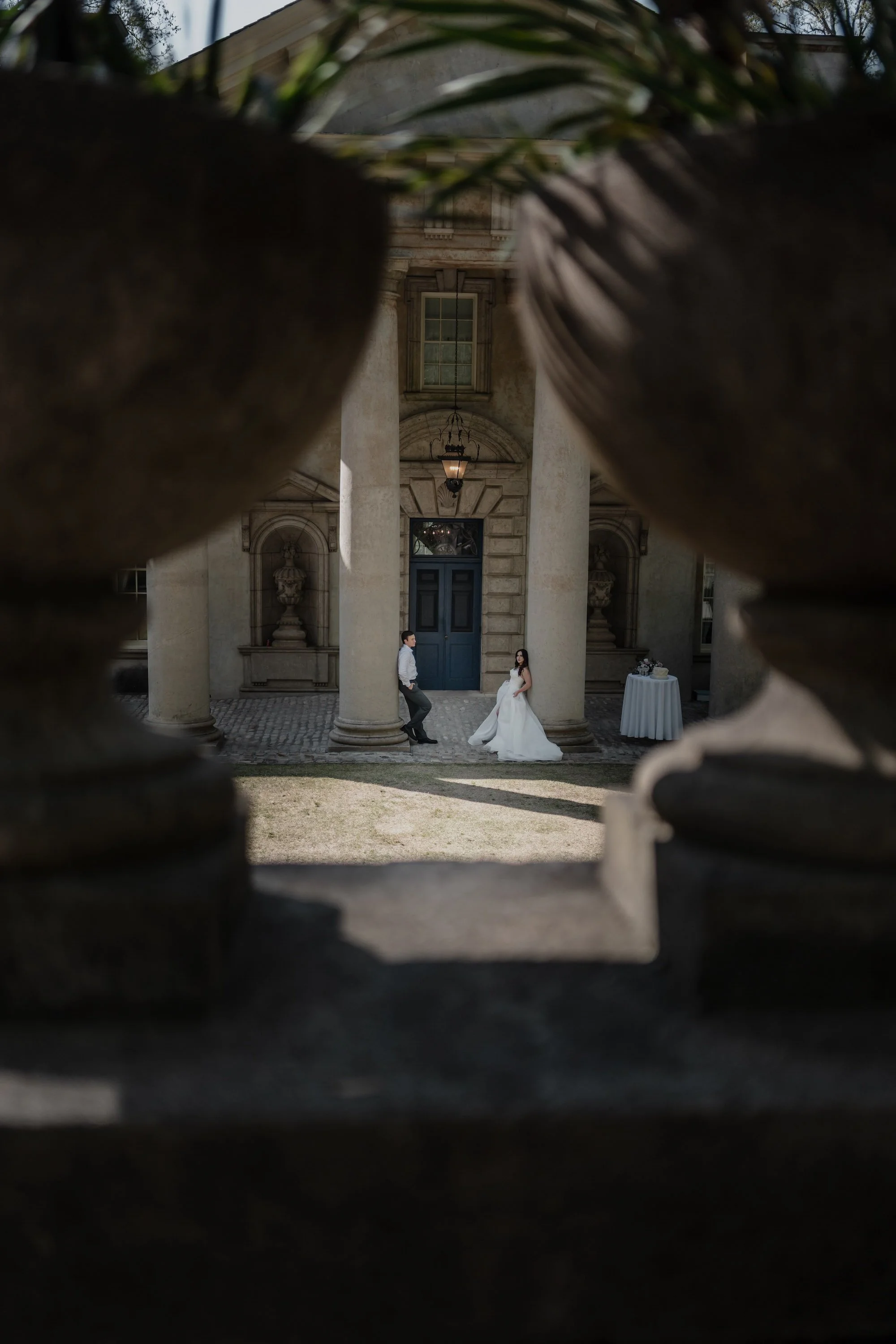 Bride walks through arches with bridesmaids behind, moment captured with editorial depth