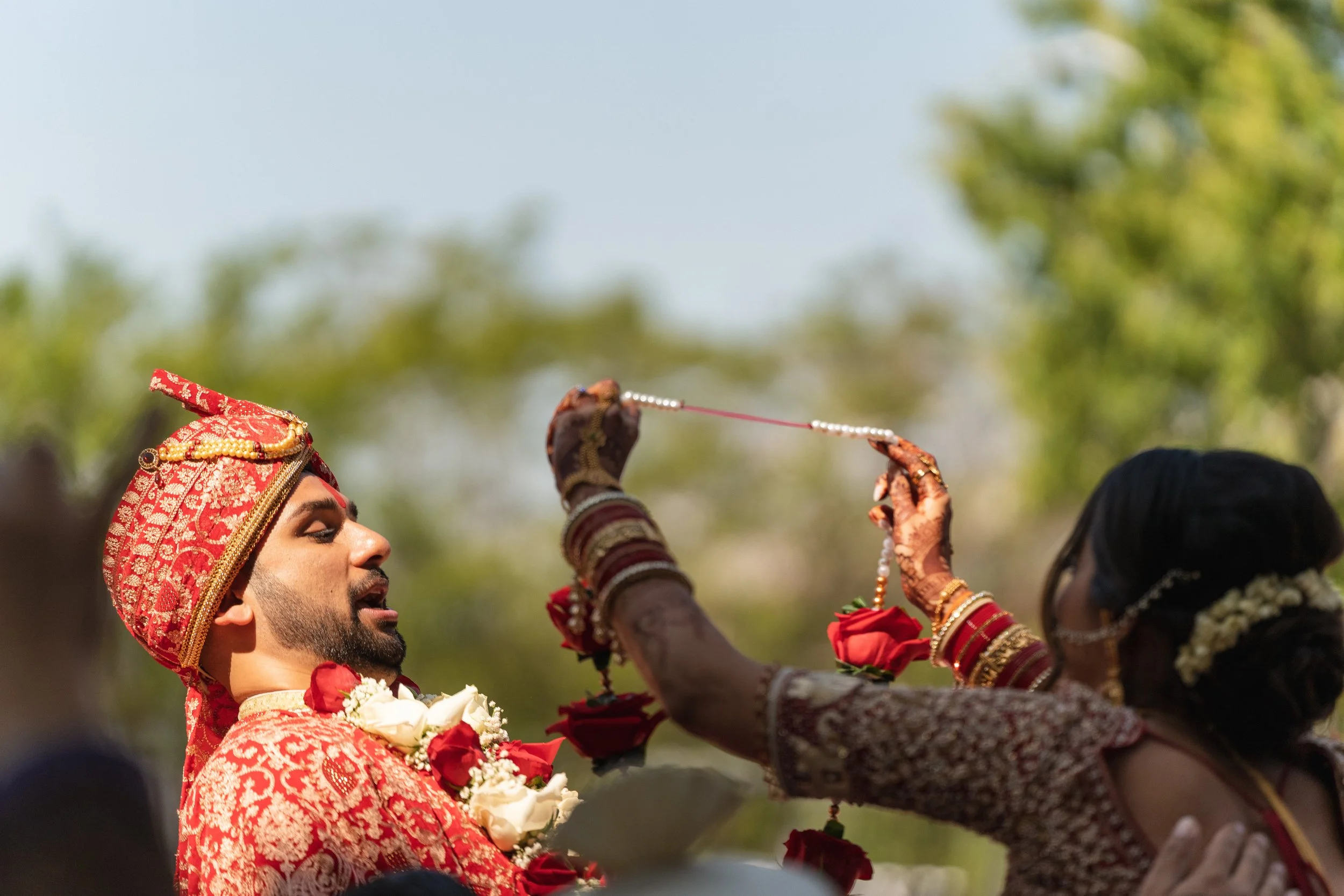 Groom playfully reaching during a traditional ceremony moment, captured by India Wedding Photographer Caz Isaiah