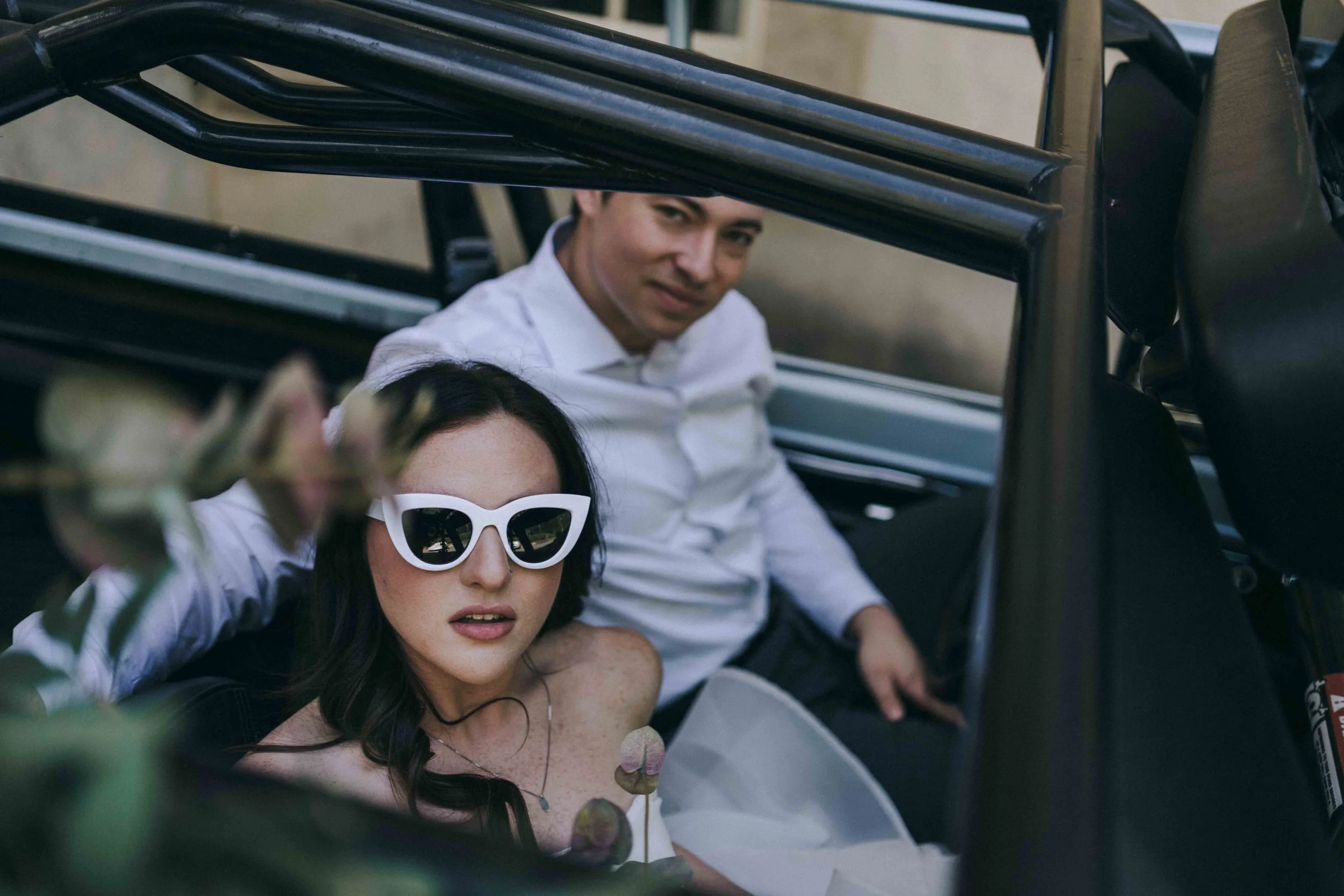 Couple sharing a kiss in an open-top jeep decorated with flowers — captured by Alila Villas Uluwatu Wedding Photographer.