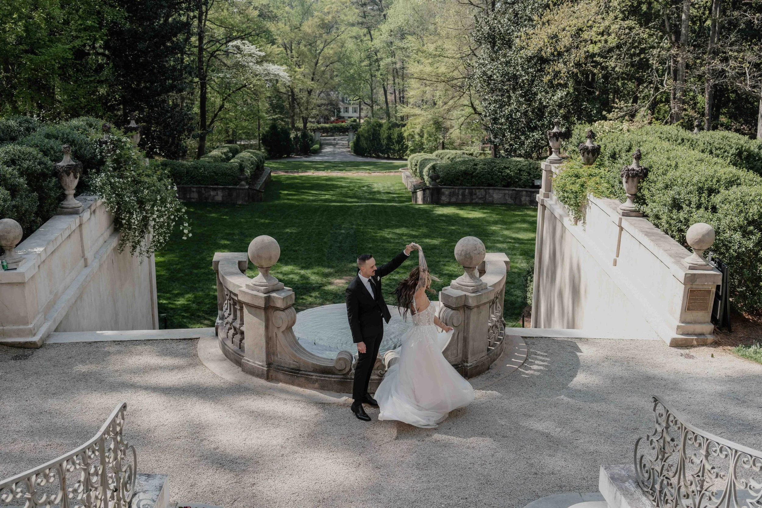 Couple shares a sweeping dance on a stone terrace, framed by gardens with timeless elegance captured by Ireland Wedding Photographer